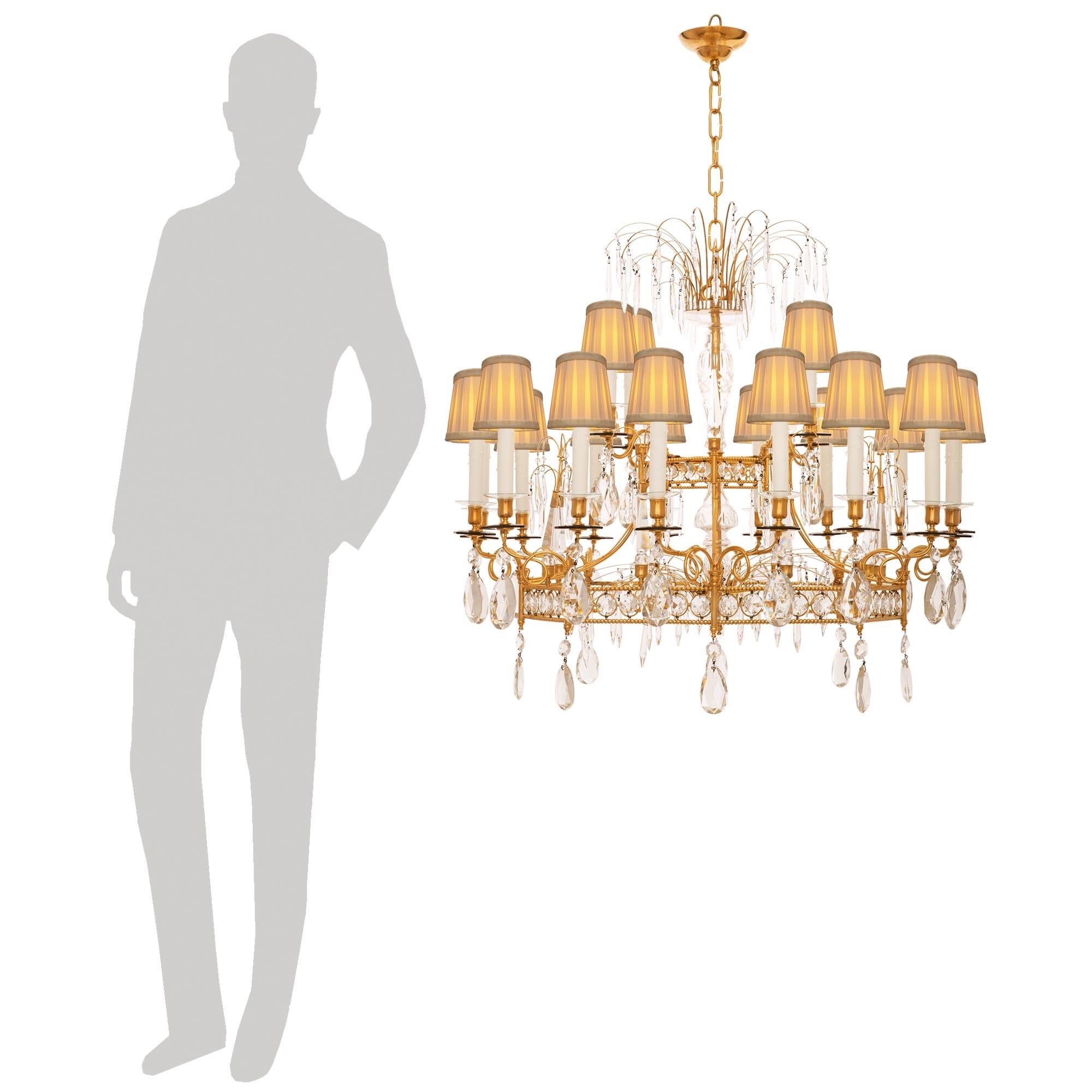 An impressive and most stately Baltic 19th century Louis XVI st. Ormolu and Crystal chandelier. This truly stunning twenty light chandelier is centered by an inverted topie shaped bottom finial that is attached below a Crystal bowl that surrounds a