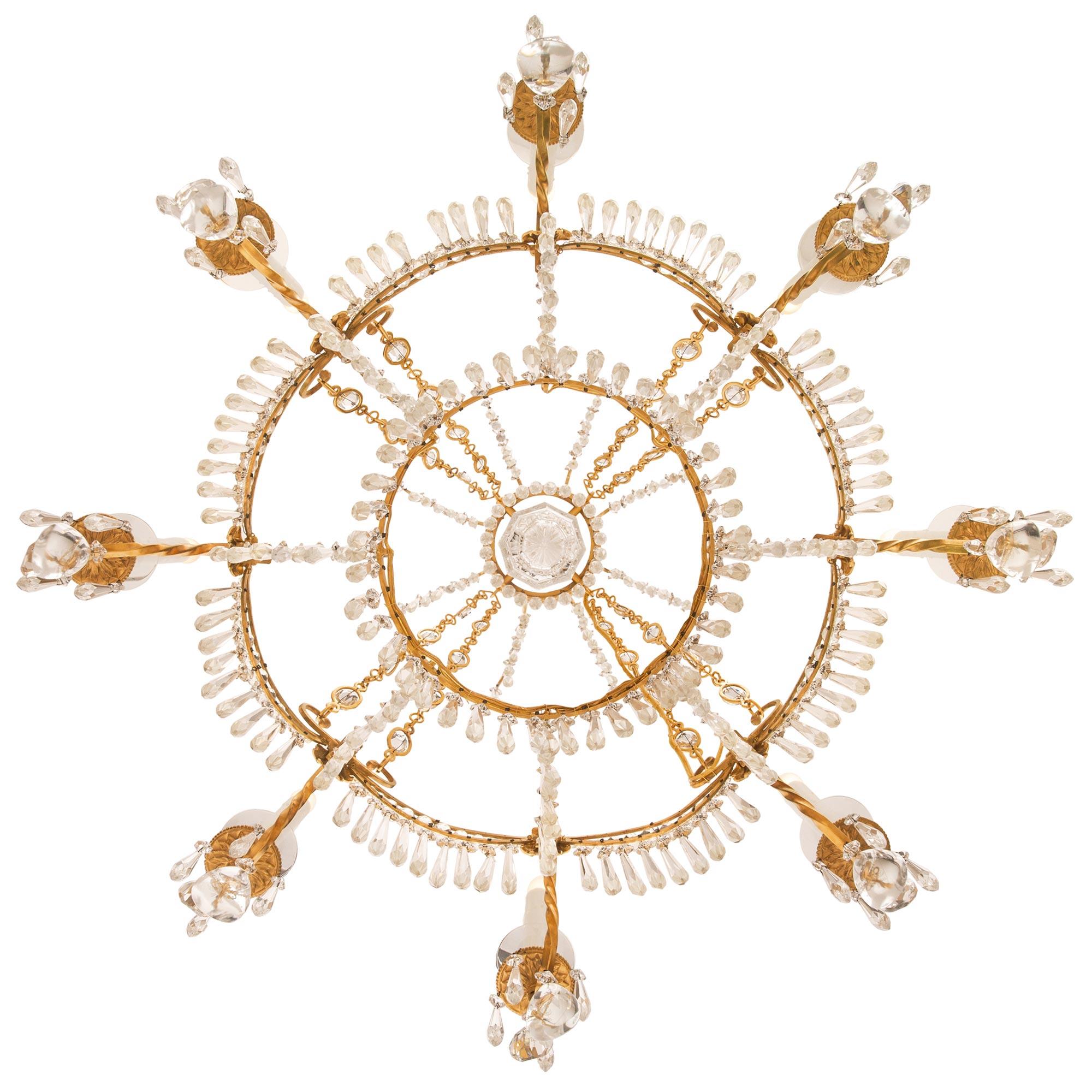 A beautiful Baltic 19th century Neo-Classical st. ormolu and crystal chandelier. The eight arm chandelier is centered by an elegant circular array of prism shaped cut crystal pendants below the most decorative curvaceous cage and lovely leaf shaped