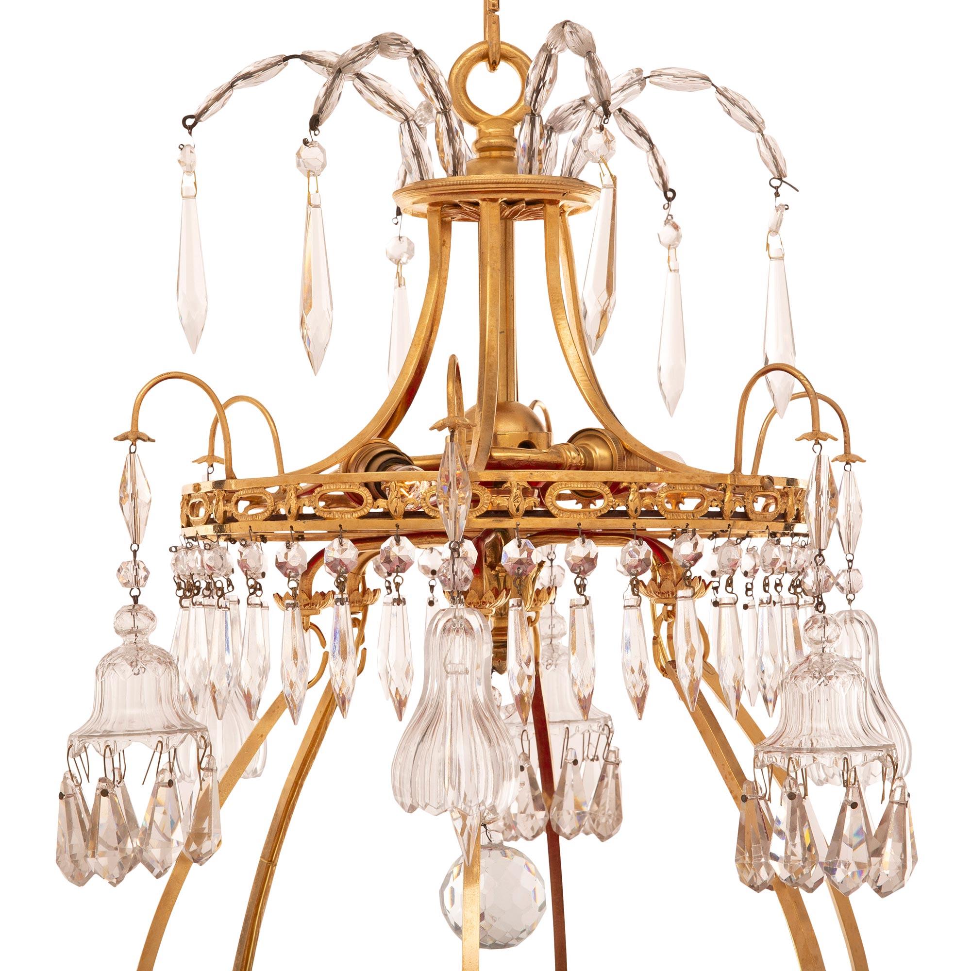 A stunning and extremely decorative Baltic 19th century Neo-Classical st. ormolu, crystal, and red glass chandelier. The six arm, nine light chandelier displays a striking circular fitted red glass pane with a superb central spray framed within a
