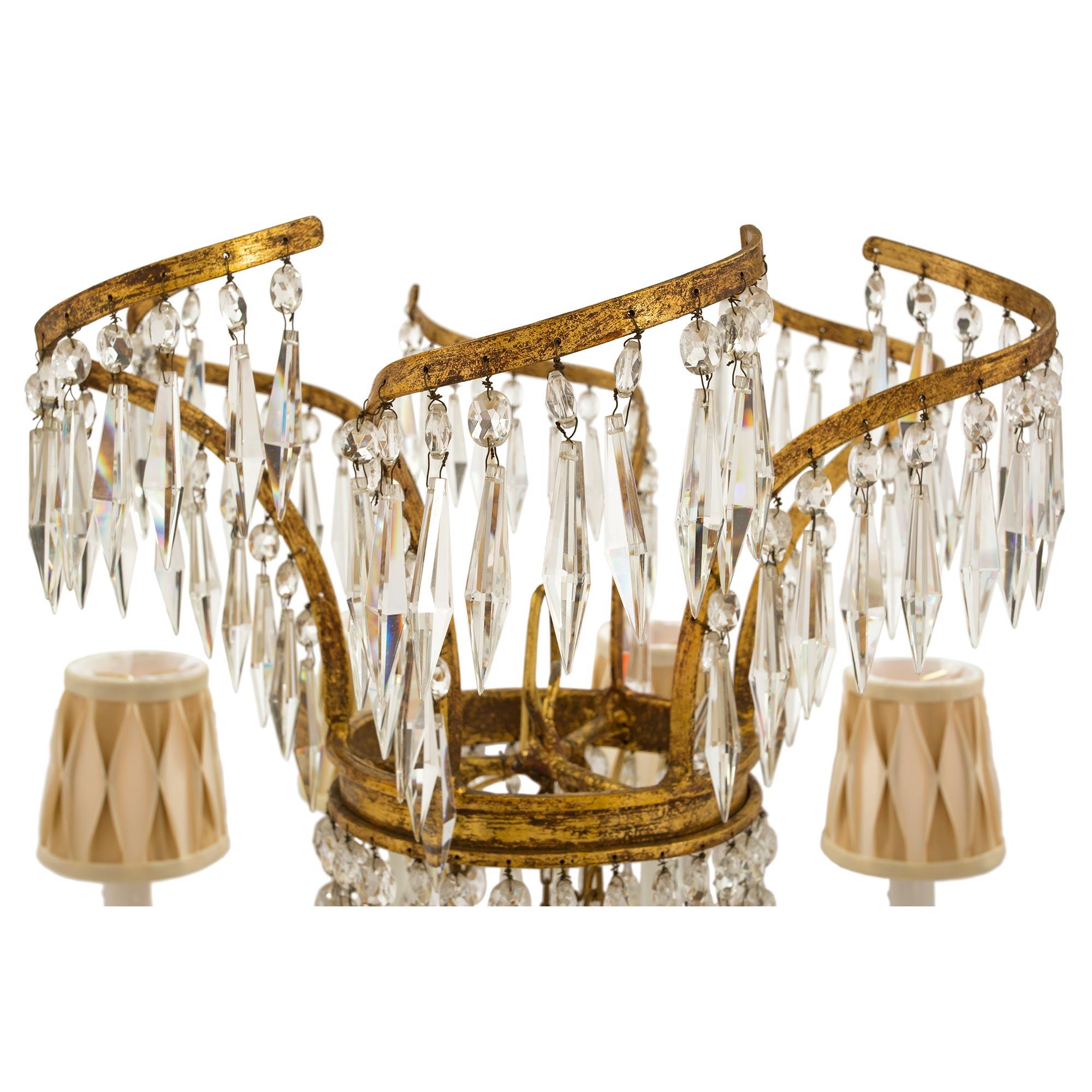 A beautiful Baltic 19th century Neo-Classical st. gilt iron and crystal, twelve light chandelier. The chandelier is centered by a a fine array of prism cut crystals arranged in a most decorative star shape. The uniquely shaped arms display
