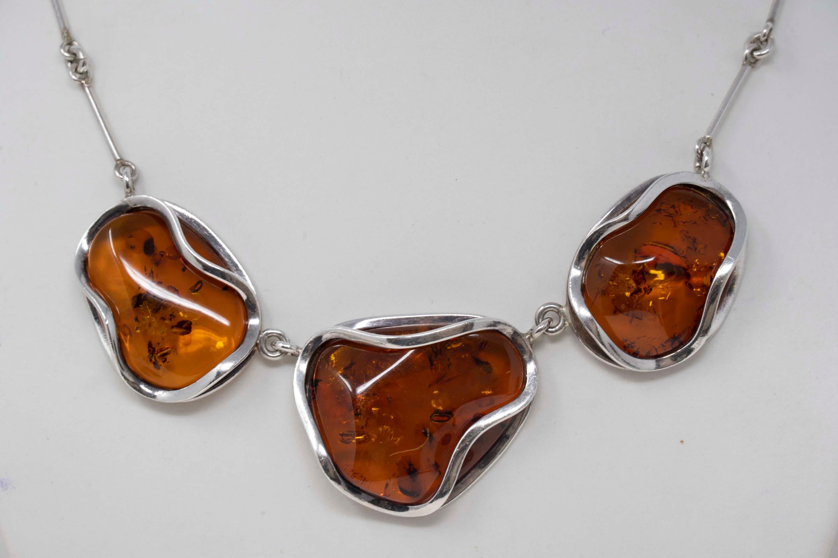 Vintage Baltic amber necklace 925 silver with three handmade pendant chain. Measures 20 inches long, the central amber pendant measures 34mm x 41 mm, 20th century. In good condition.

