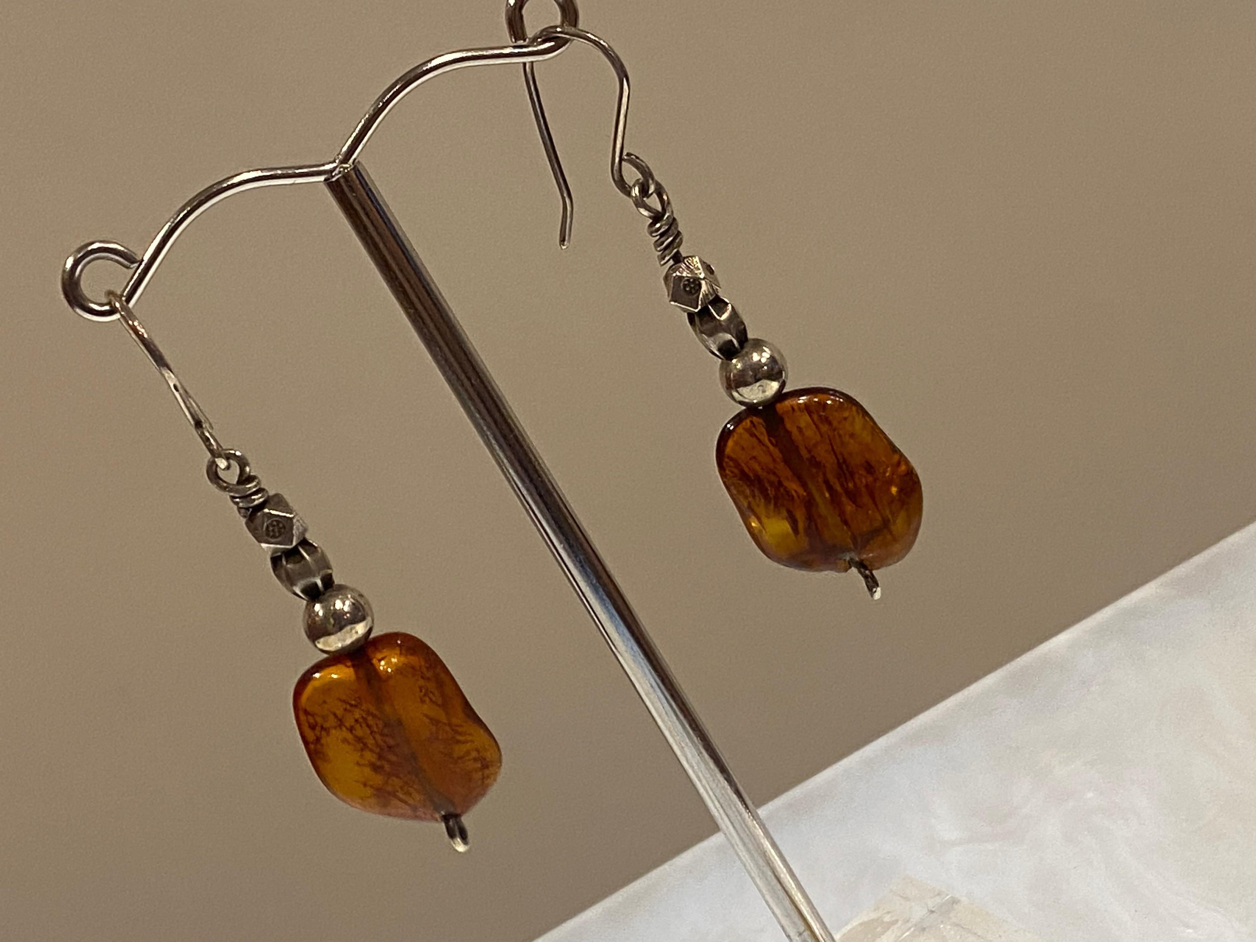 Elegant vintage set comprising of: 

 

A ring, bezel set with a Natural Amber, 

of oval shape, measuring 16mm x 13mm 

with finely detailed shoulders, 

set in 925 sterling silver 

 

Matching Drop Earrings, 

featuring finely detailed bails &