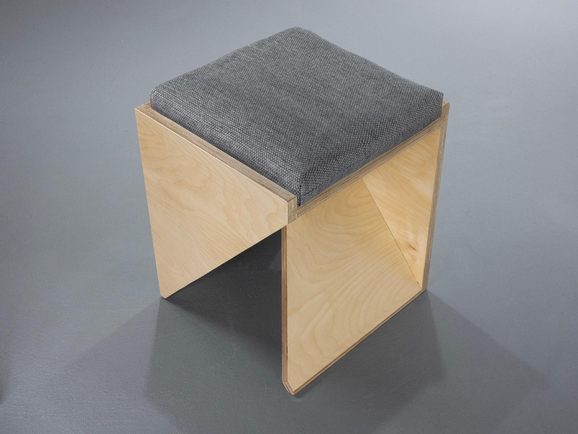 The Stool is made from premium Baltic Birch Plywood. Its legs are formed by two folded prisms that lock together in the center. The stool is both functional and sculptural, changing shape depending on the angle of view. It includes a 16 x 16” cotton