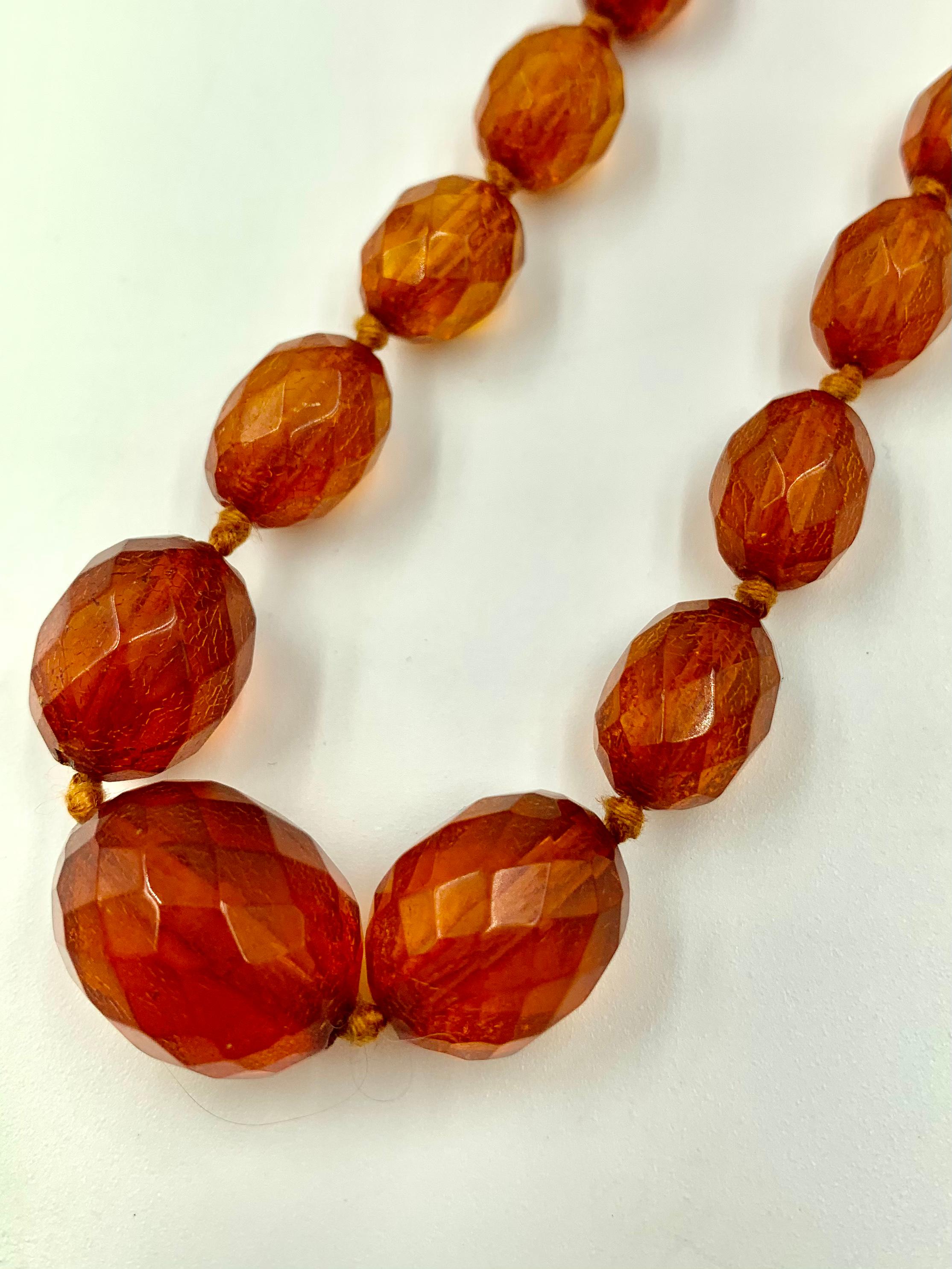 Natural antique honey colored amber necklace composed of 42 oval hand faceted natural amber beads 19mm to 10mm. Very good condition, the beads translucent and showing lovely crazing consistent with antique amber.
Amber has a naturally occurring