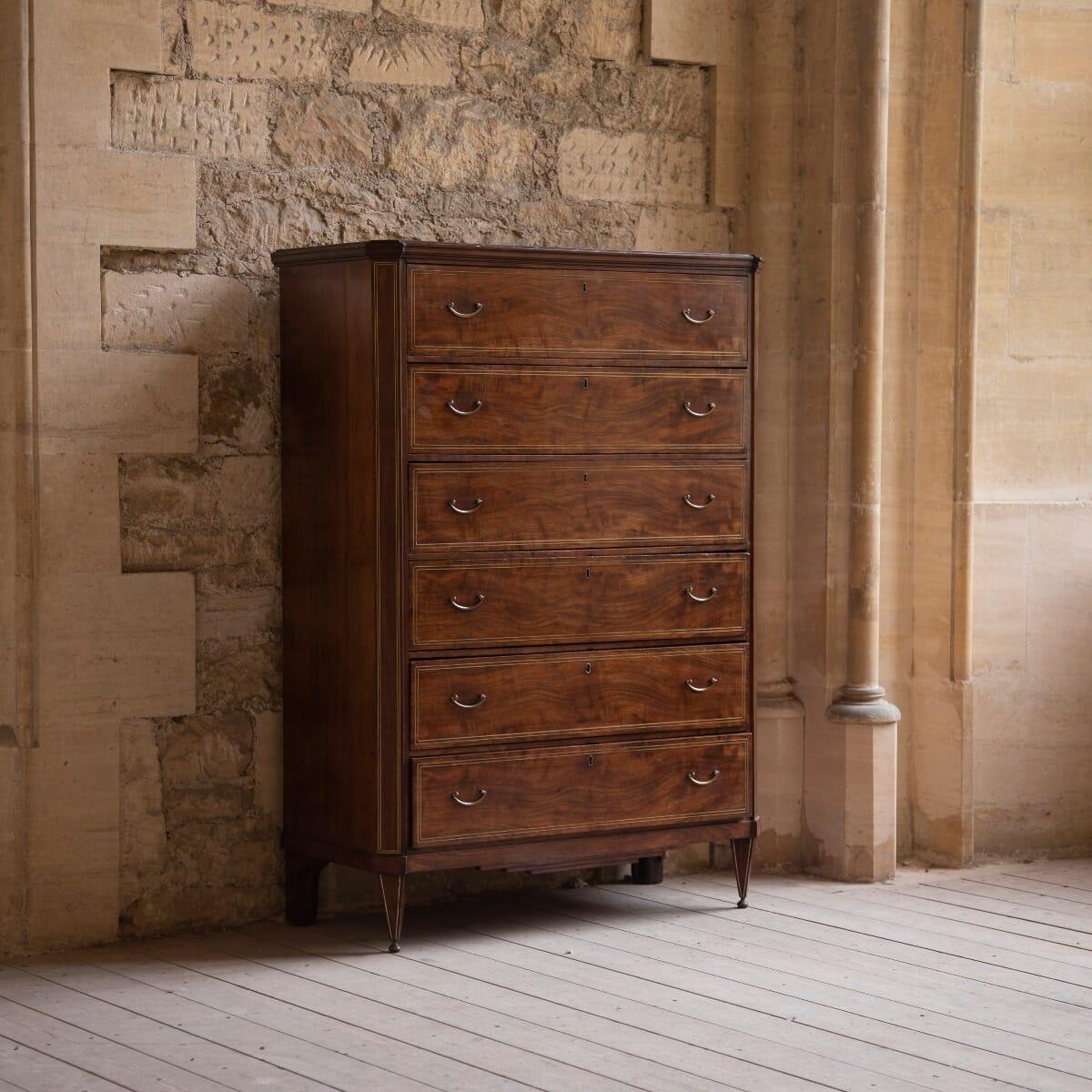 A mahogany tall chest of six long drawers, circa 1810.

From the Baltic region, possibly Russian. Superb quality, with oak drawer linings and matched veneers to each drawer face.

With its canted corners and a continuous double line brass inlay,