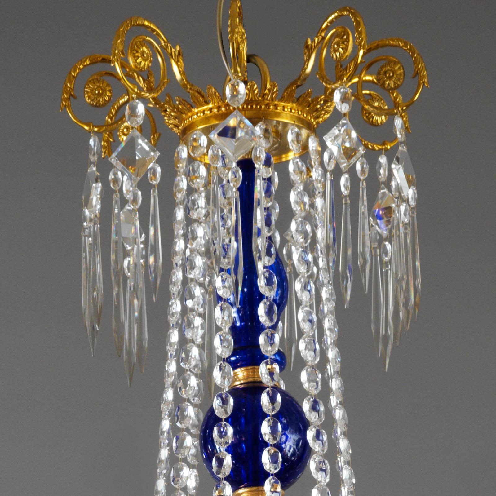 This Neoclassical Baltic Style Chandelier 54-lights by Gherardo Degli Albizzi, is enriched with Cobalt Blue glass .
The elegant top crown suspends Bohemian crystal drops supported by a cobalt blue glass centerpiece.
This chandelier features five