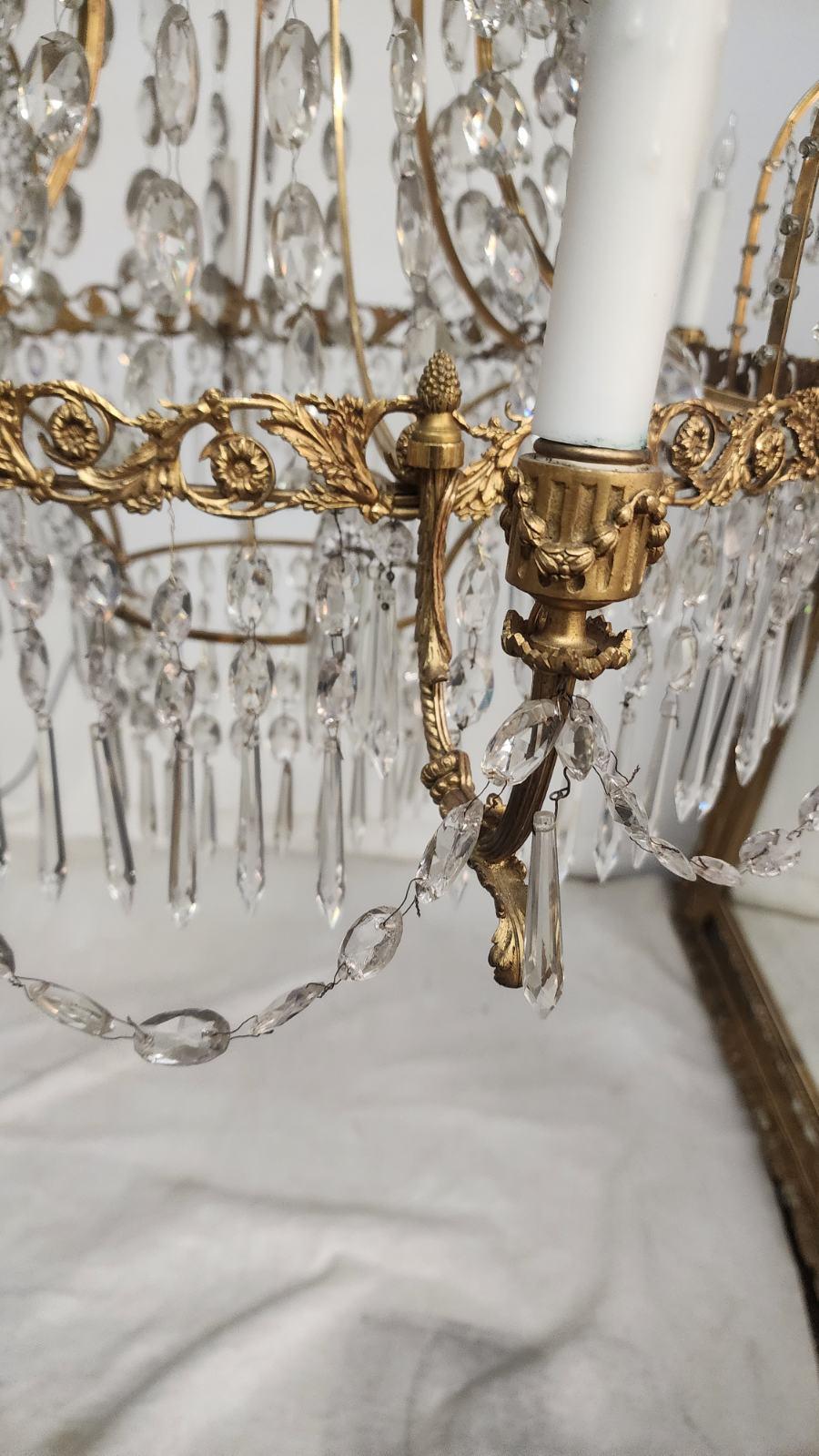 Beautiful six-light chandelier. In the style Baltic Neoclassical with gilt bronze and cut glass. Has intricate designs on the frame and arms. 
