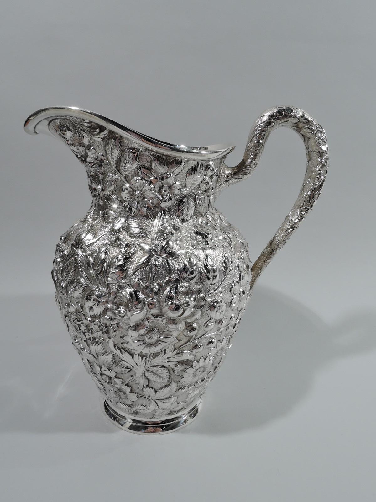 Victorian sterling silver drinks set. Made by AG Schultz & Co. in Baltimore, ca 1910. This set comprises 1 pitcher and 12 goblets. Pitcher has curved and tapering body, high-looping handle, and helmet mouth. Goblets have ovoid bowl on cylindrical