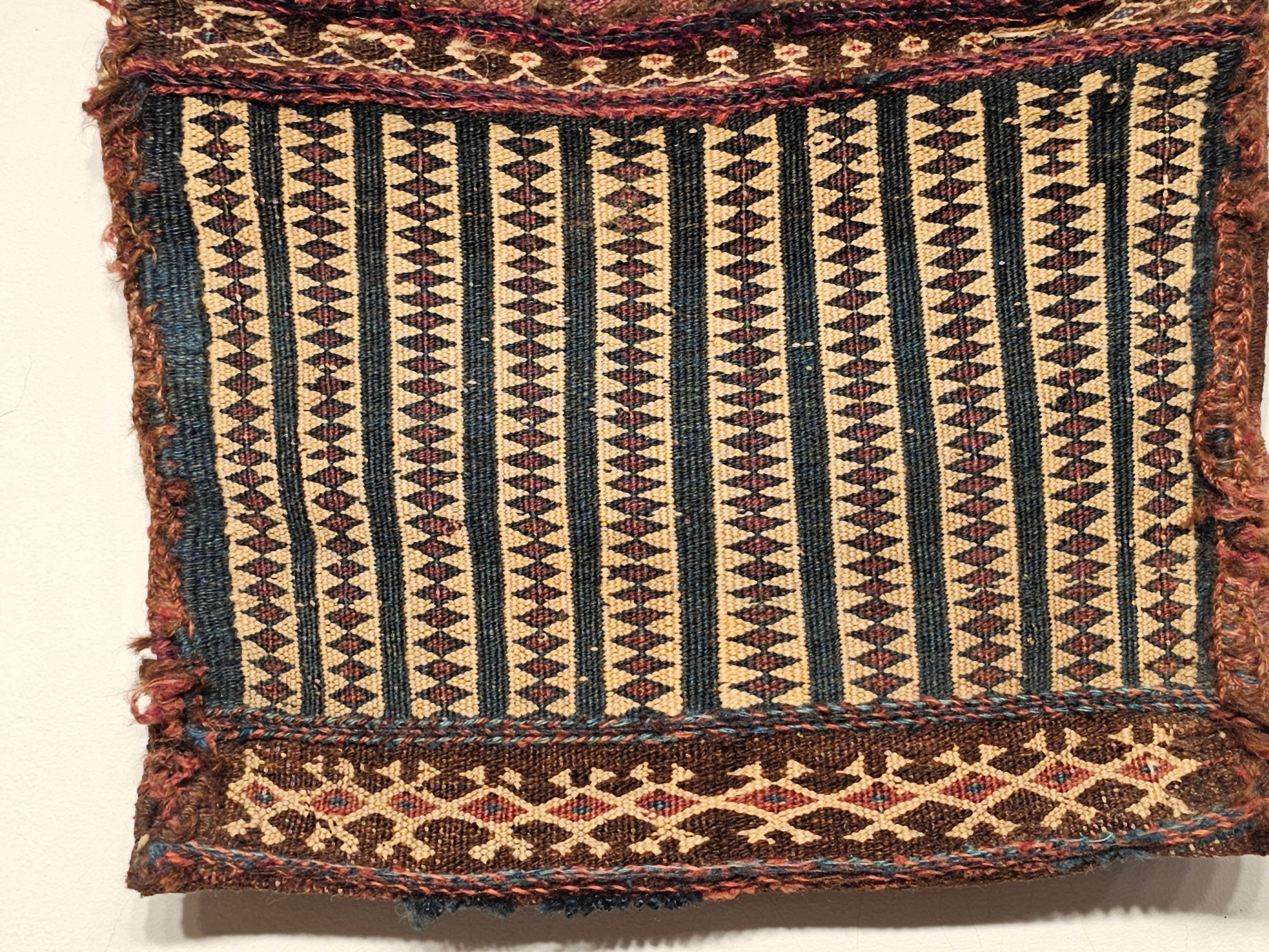 A 19th century Persian Baluch tribal soumak double saddlebag.   The front of the bag has a beautiful geometric design in a green/blue color set on a yellow background.  The variation in color in the green/blue design is very beautiful.  The Baluch