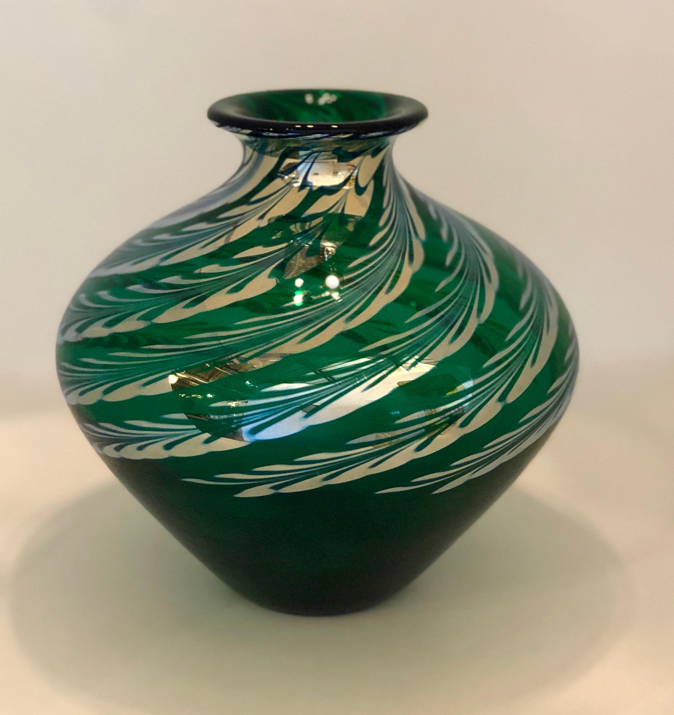 The offered glass art vase is a Mid-Century Modern baluster form iridescent green vase with silver feather swirl decoration and etched signature of Steven Correia on the bottom, numbered 