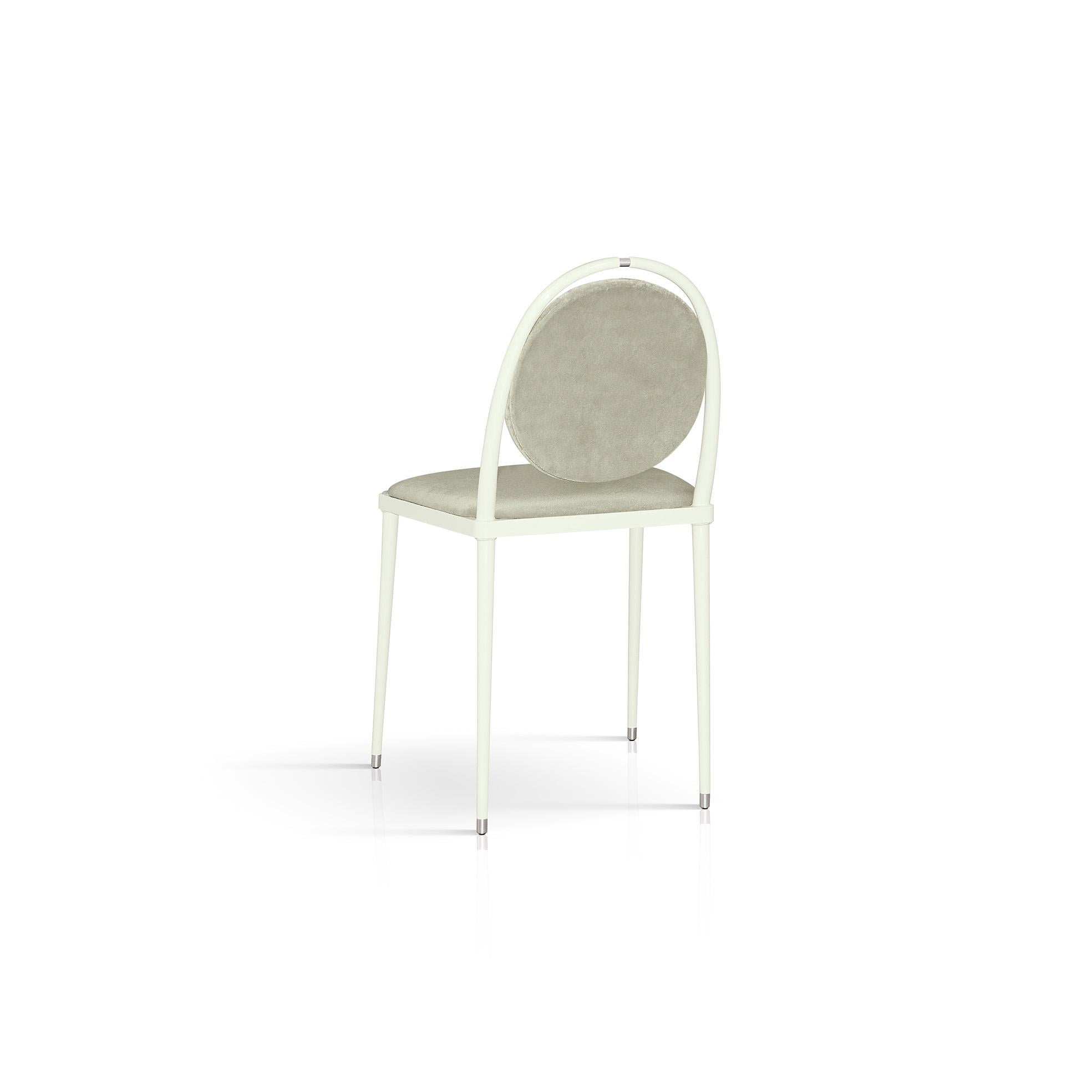A simple and modern aesthetics enriched with refined details, this chair of the Balzaretti series features a medallion backrest and generous square seat upholstered in soft mint green velvet. The ergonomic design and the glossy ivory metal frame