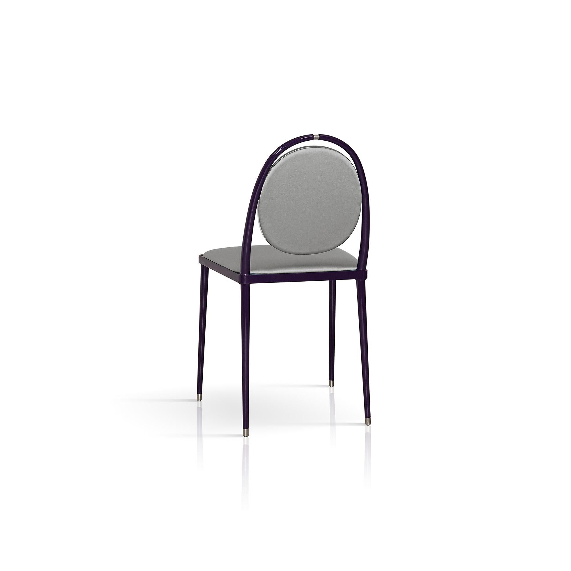 This chair combines simplicity, perfection, and elegance in a simple geometry made of curves and straight lines inspired by primary shapes and colors. Built on a metal frame with slender legs, the glossy purple finish complements the silver silk