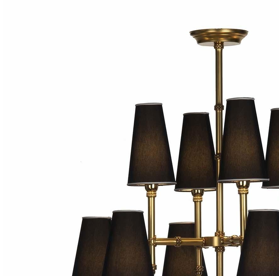 A piece of rare elegance, this superb chandelier will stand out in a classical or modern decor with its dynamic structure. Fashioned of brass with a satin gold finish, the frame is defined by sleek lines and proportions, with a central rod