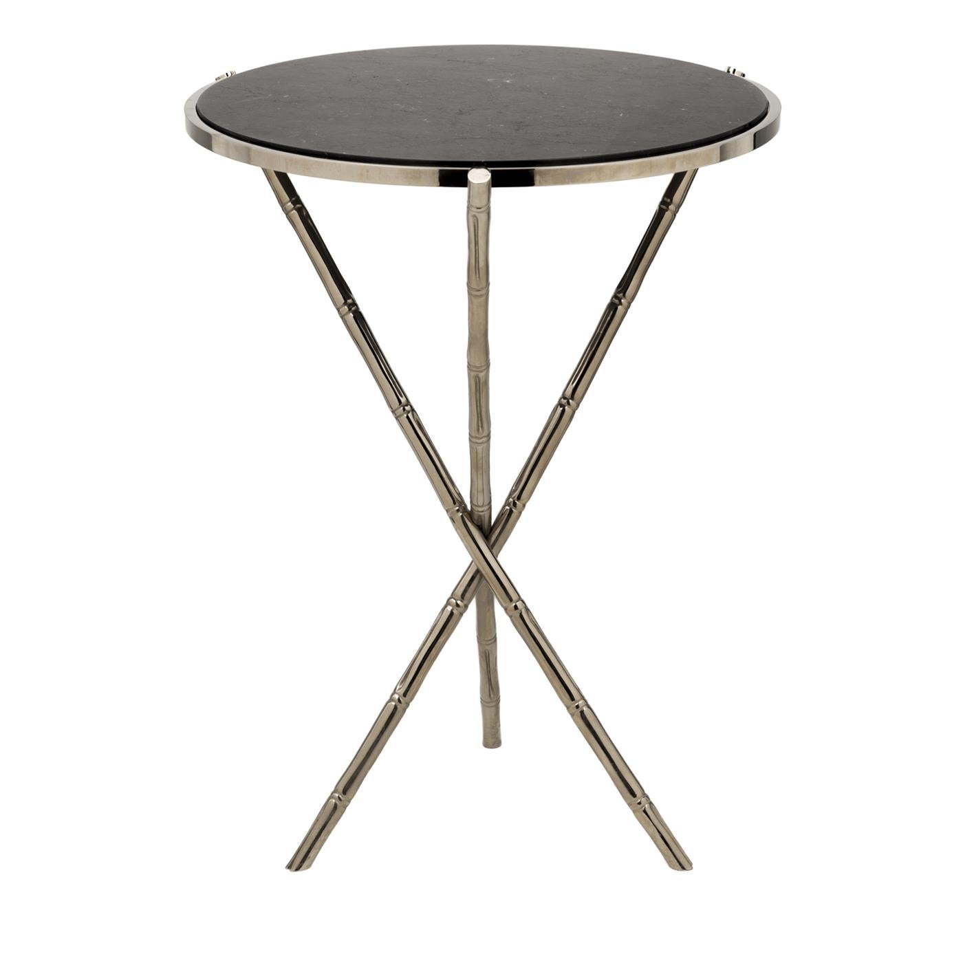 This table, with its simple lines and precious materials, will complement any decor. Its three crossing legs in brass are given a bamboo-like texture and their subtle finish elegantly complements the round top in marble. Either by the sofa in a