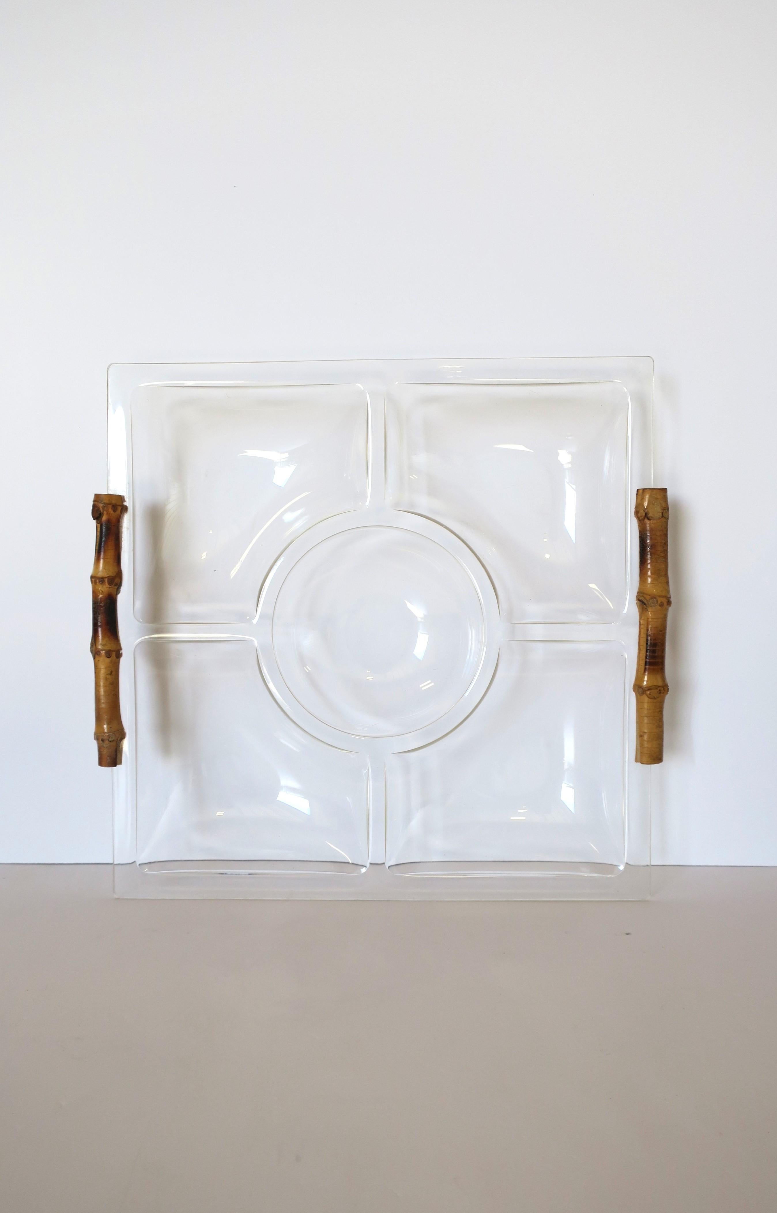 A transparent acrylic and authentic bamboo handle sectional serving tray, 1977. Piece is in the modern / Chinoiserie design style. Tray has 5 sections, one round center bowl area, and four (4) coordinating triangular bowl areas around. Box read