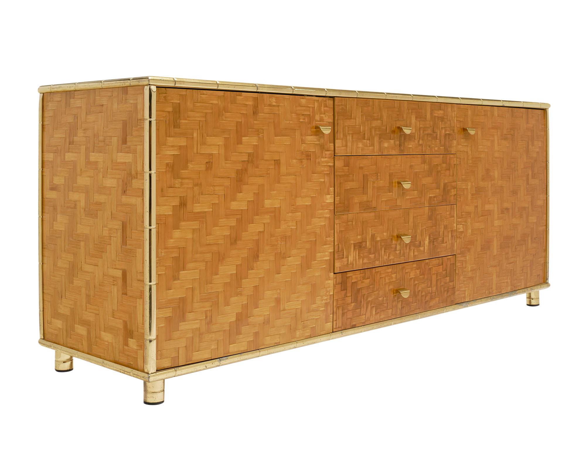 Italian Mid Century Modern buffet with 2 doors and 4 drawers. The gilt brass frame, which emulates bamboo, showcases the body of the cabinet that is covered in a bamboo veneer.
