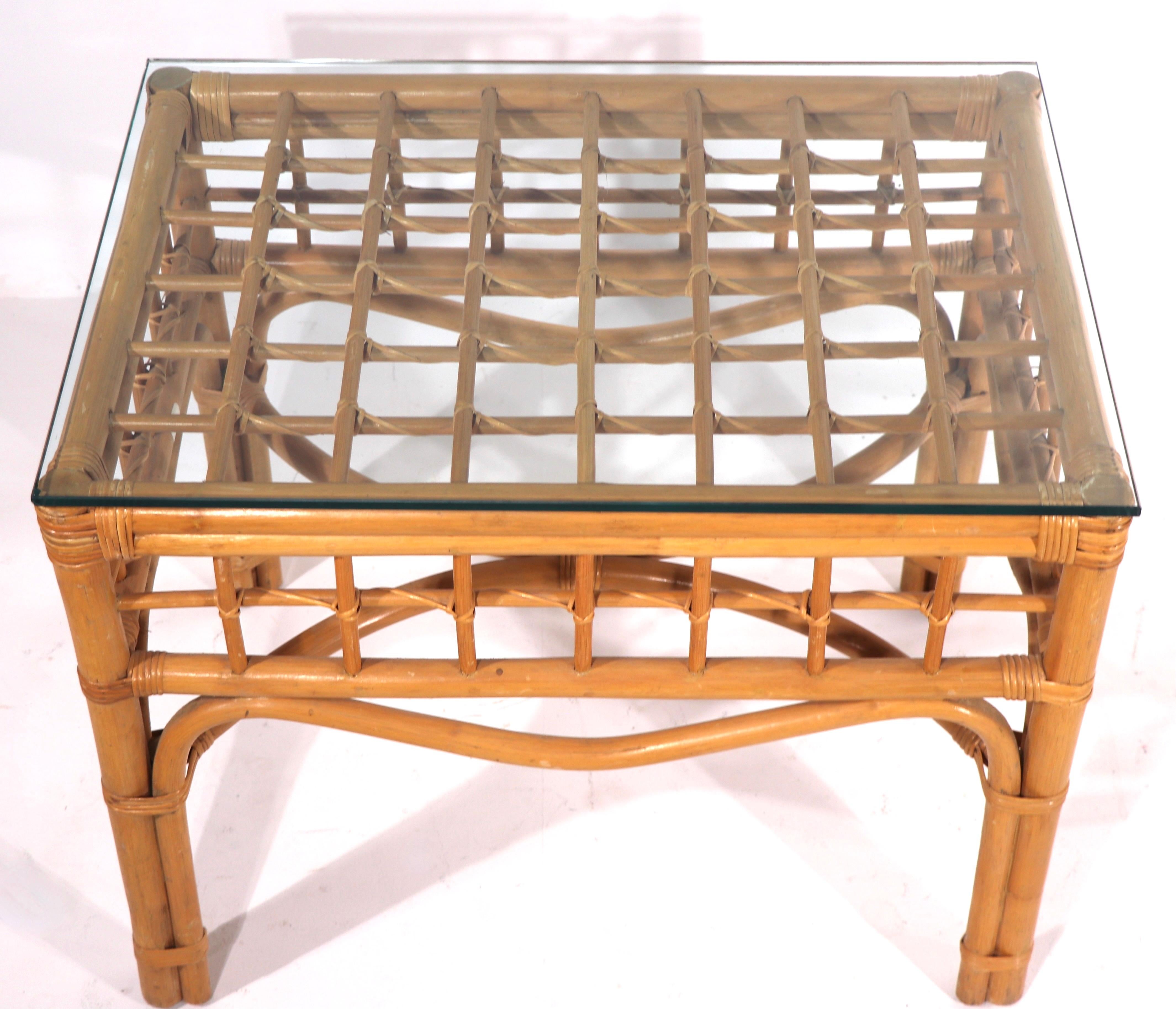 High quality and well made bamboo end, or side, table having woven wicker trim, bamboo legs, and a glass top. In the style of Olko, Link, McGuire -Ficks Reed etc. unsigned. Please view the companion bamboo pieces we have listed separately from this