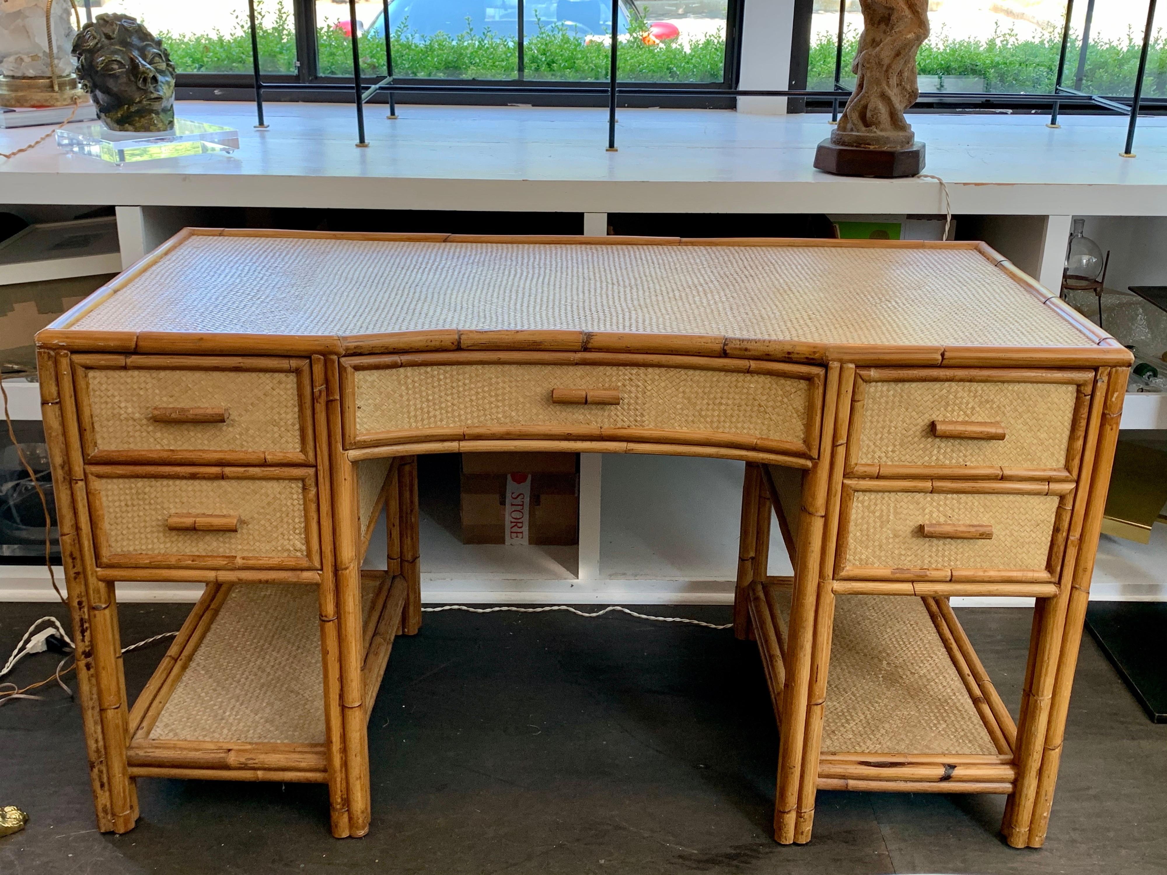 Midcentury British colonial desk with 3-drawers and a filing drawer. Wrapped in grass cloth and framed in bamboo, this exceptionally preserved vintage desk has lots of storage. Finished all around (the back as well) which is perfect for floating in