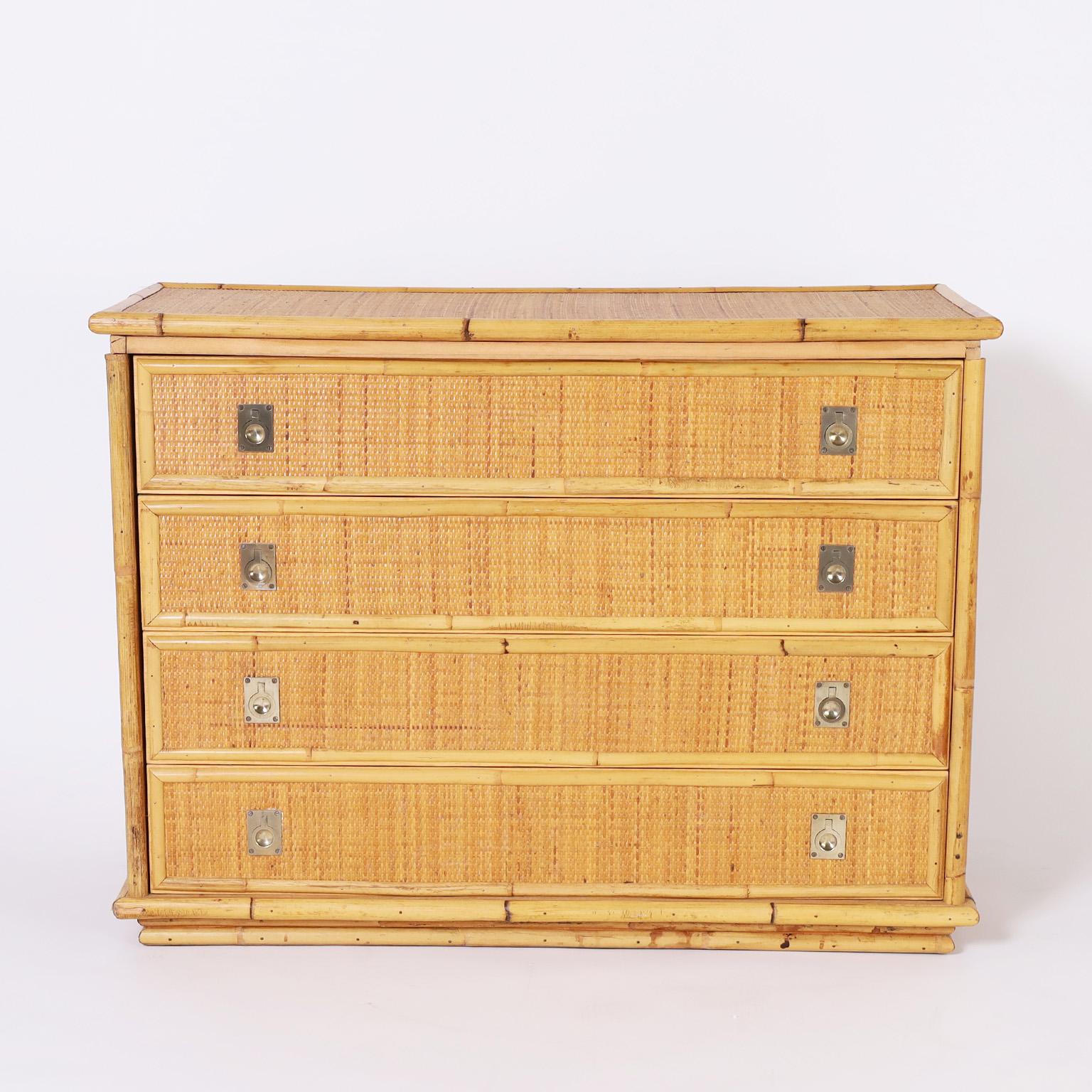 Chic mid-century Italian four drawer chest or commode crafted with a bamboo frame around grasscloth panels featuring brass campaign style hardware.