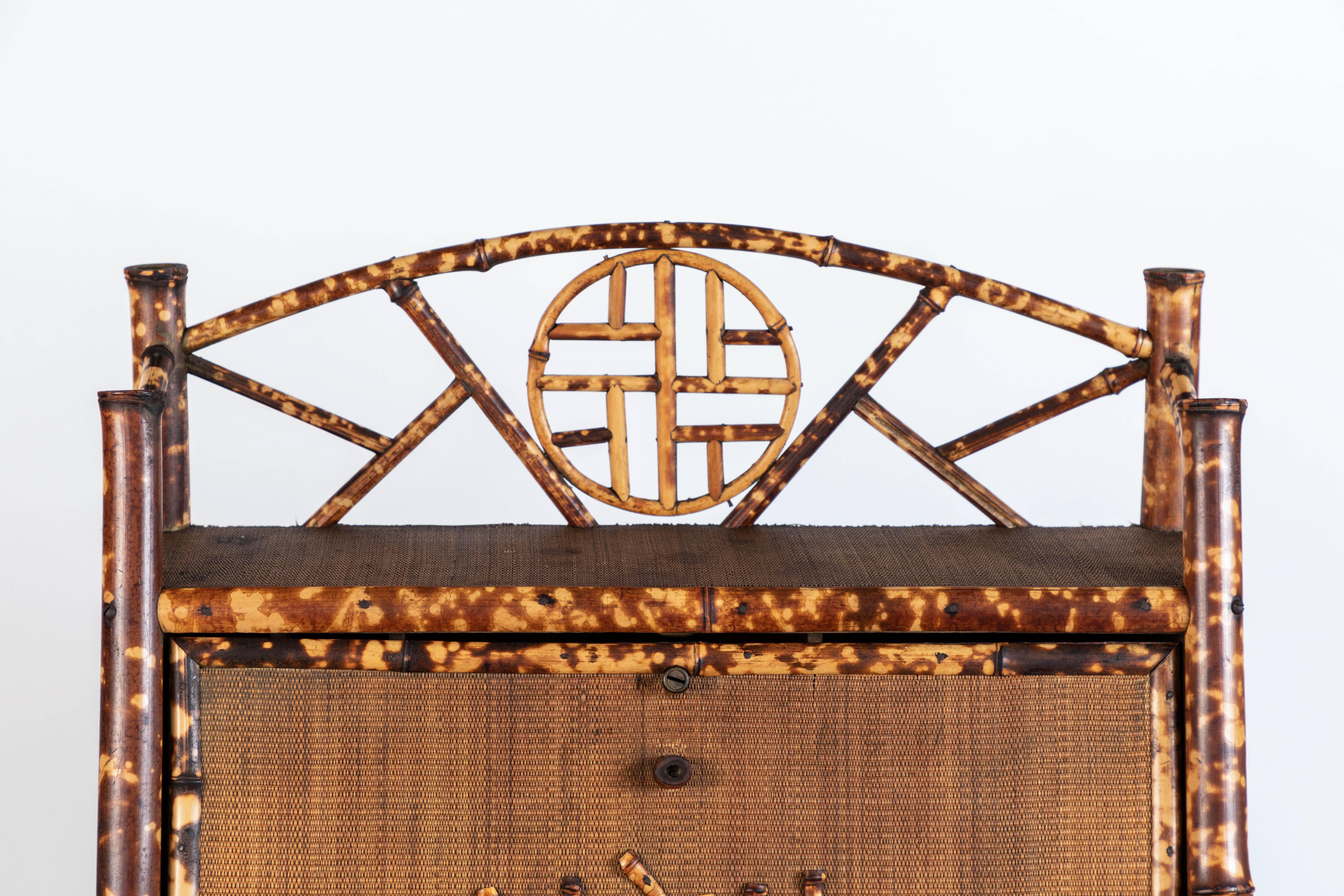 Exuberant and tidy ball and stick style bamboo and grasscloth secretary desk with interior cubbies and bottom shelf, circa 1890s.

Minor damages, as shown in photos.