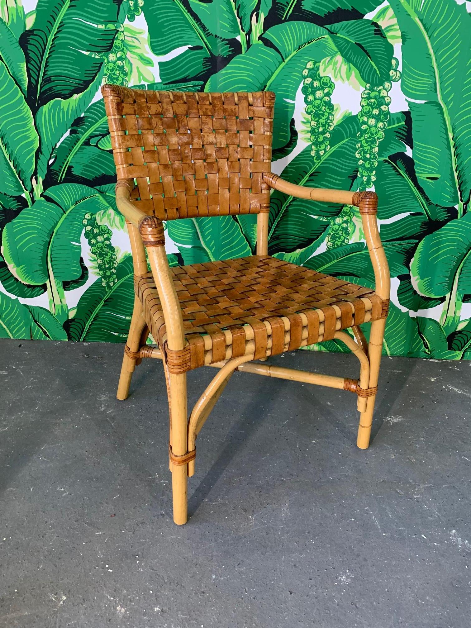 Set of 4 bamboo dining chairs by McGuire feature woven leather seats and backs. Very good vintage condition with minor imperfections consistent with age. Matching table available, see our other listings. Arm height is 26.5