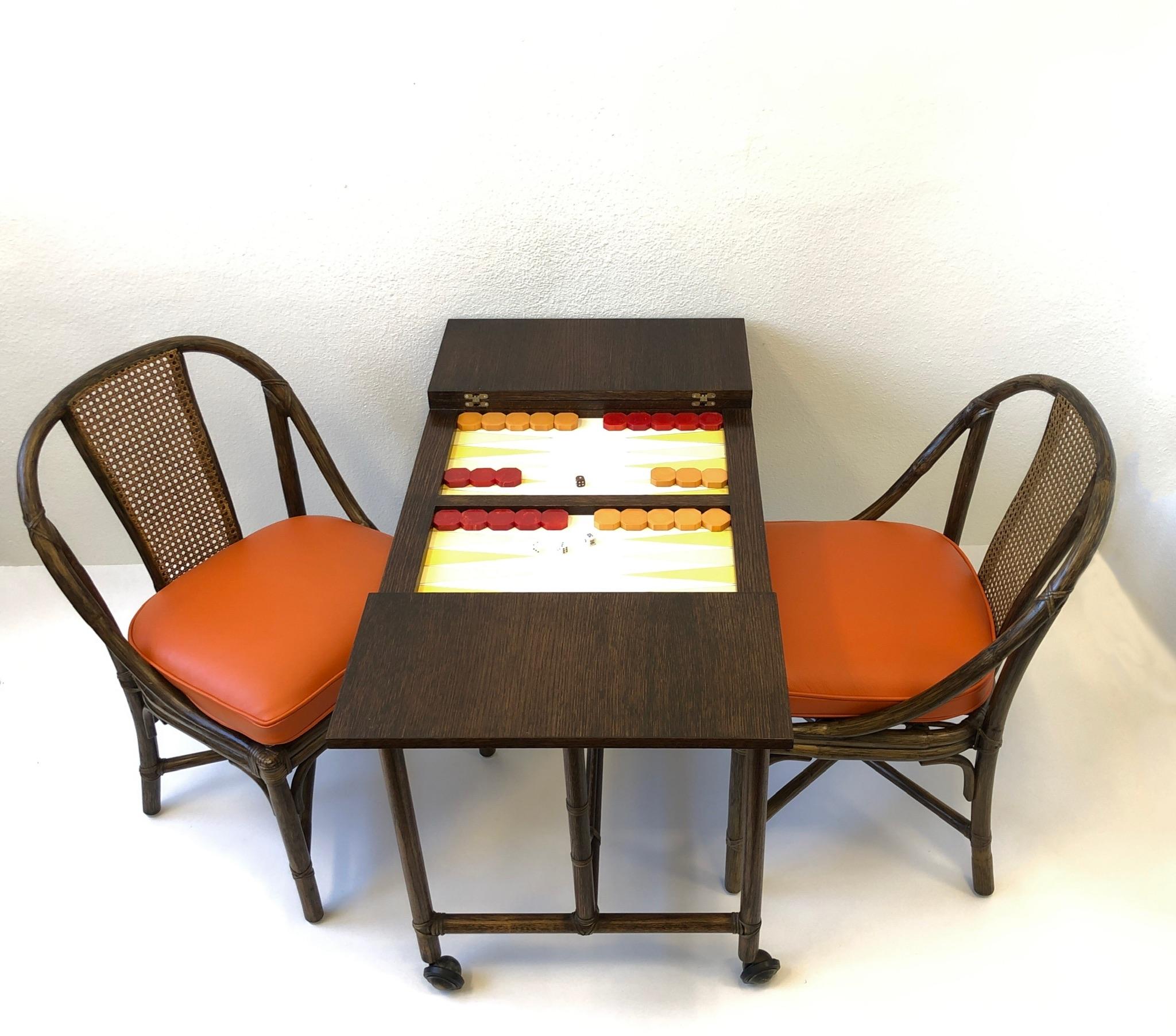 Rare backgammon game table and chairs designed by McGuire from the 1960s. Can be closed up to play cards or used as a console table. Table is constructed of dark oak and bamboo. Game board is leather and the playing pieces are bakelite.
New orange