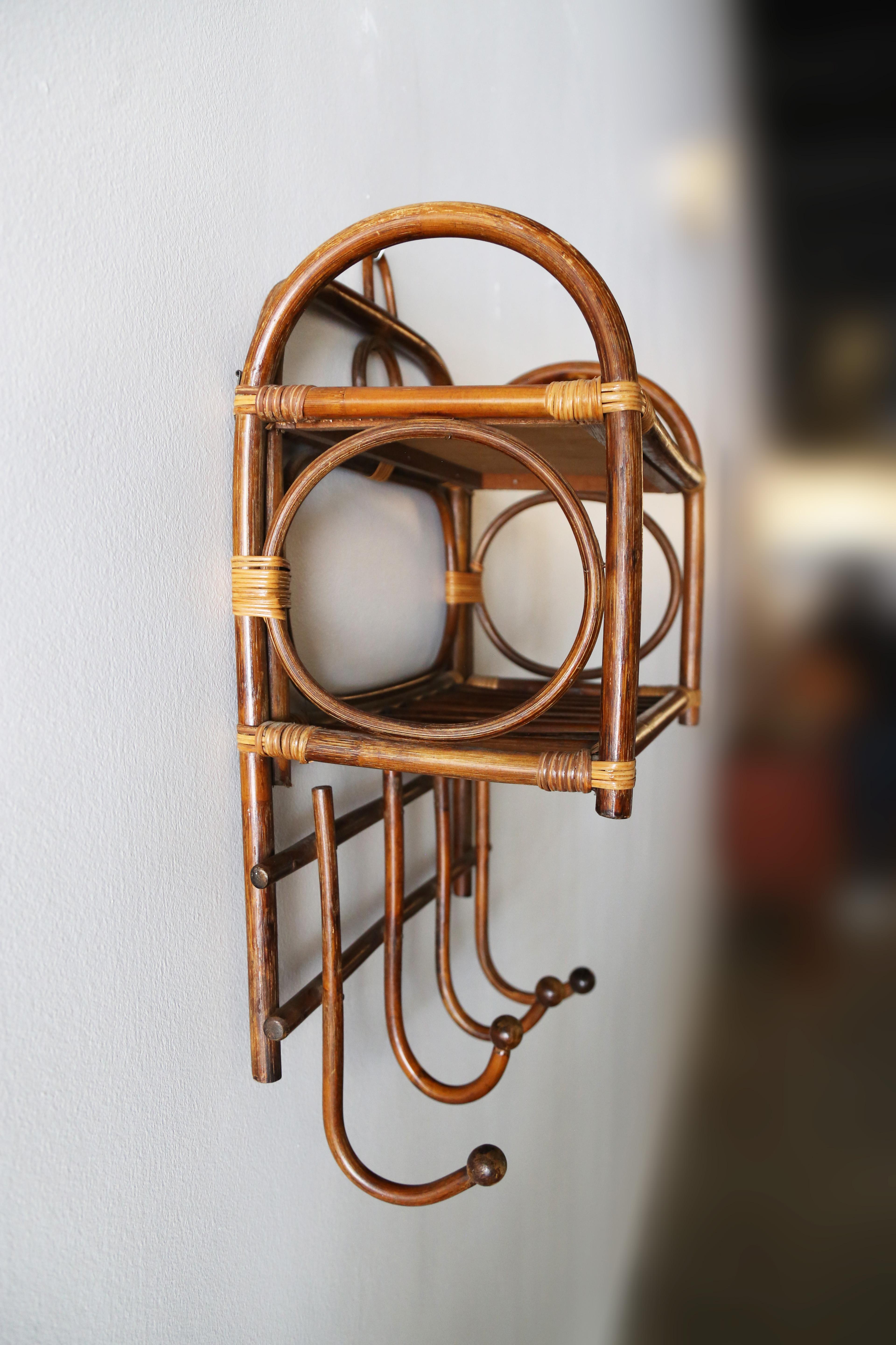 A unique vintage shelf in Rattan, Caning, and Bamboo. This shelf would be great in an entryway or in a bathroom or guest bedroom. Great organic design with a repitition of circles to lighten the shelf. The sides are adorned with arches. Steam bent