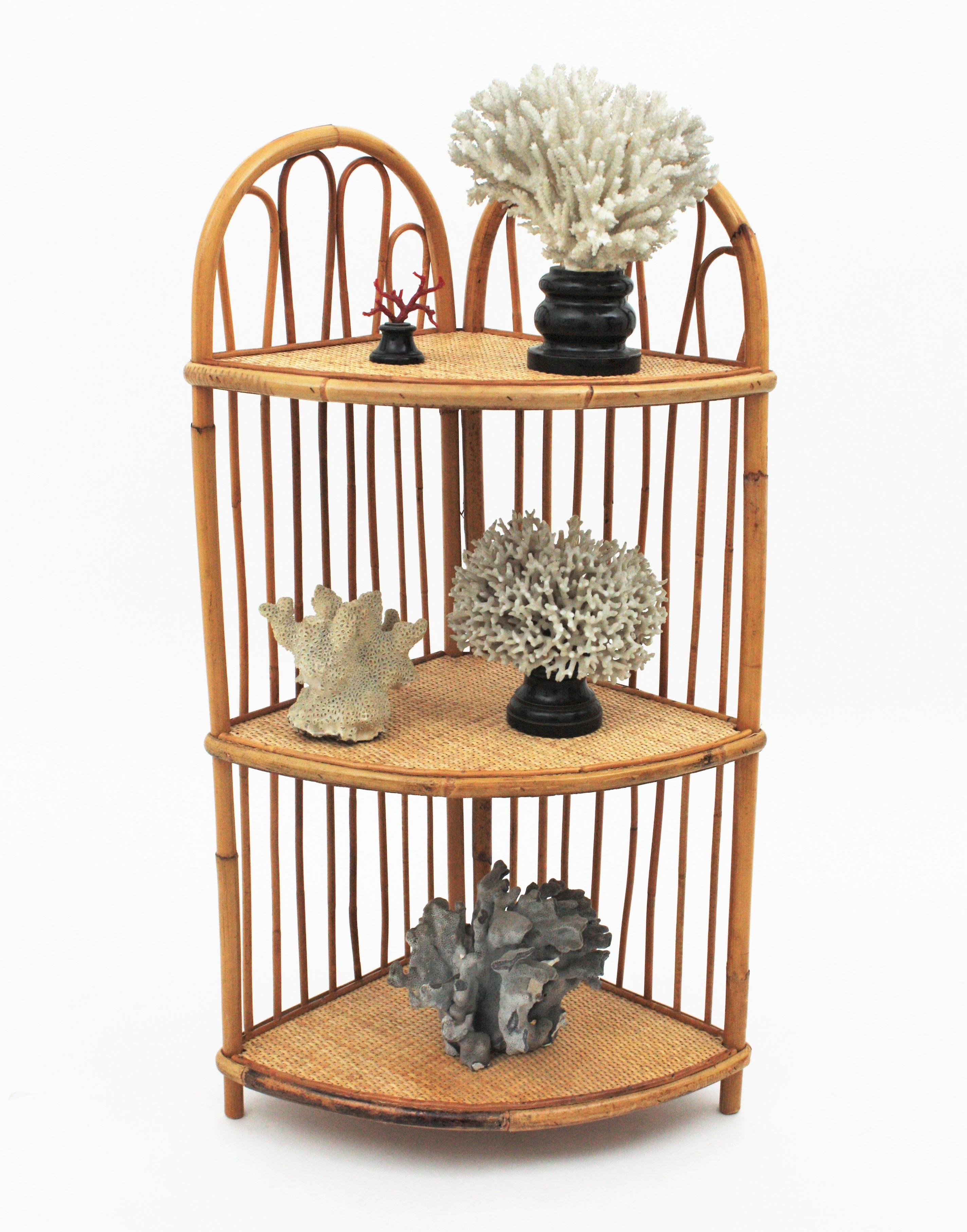 Eye-catching corner wall hanging or floor shelf / stand in bamboo and rattan, Spain, 1960s.
This étagère has 3 shelves covered with rattan wire. The structures is made in bamboo with rattan decorative accents at both sides. To be placed in a corner