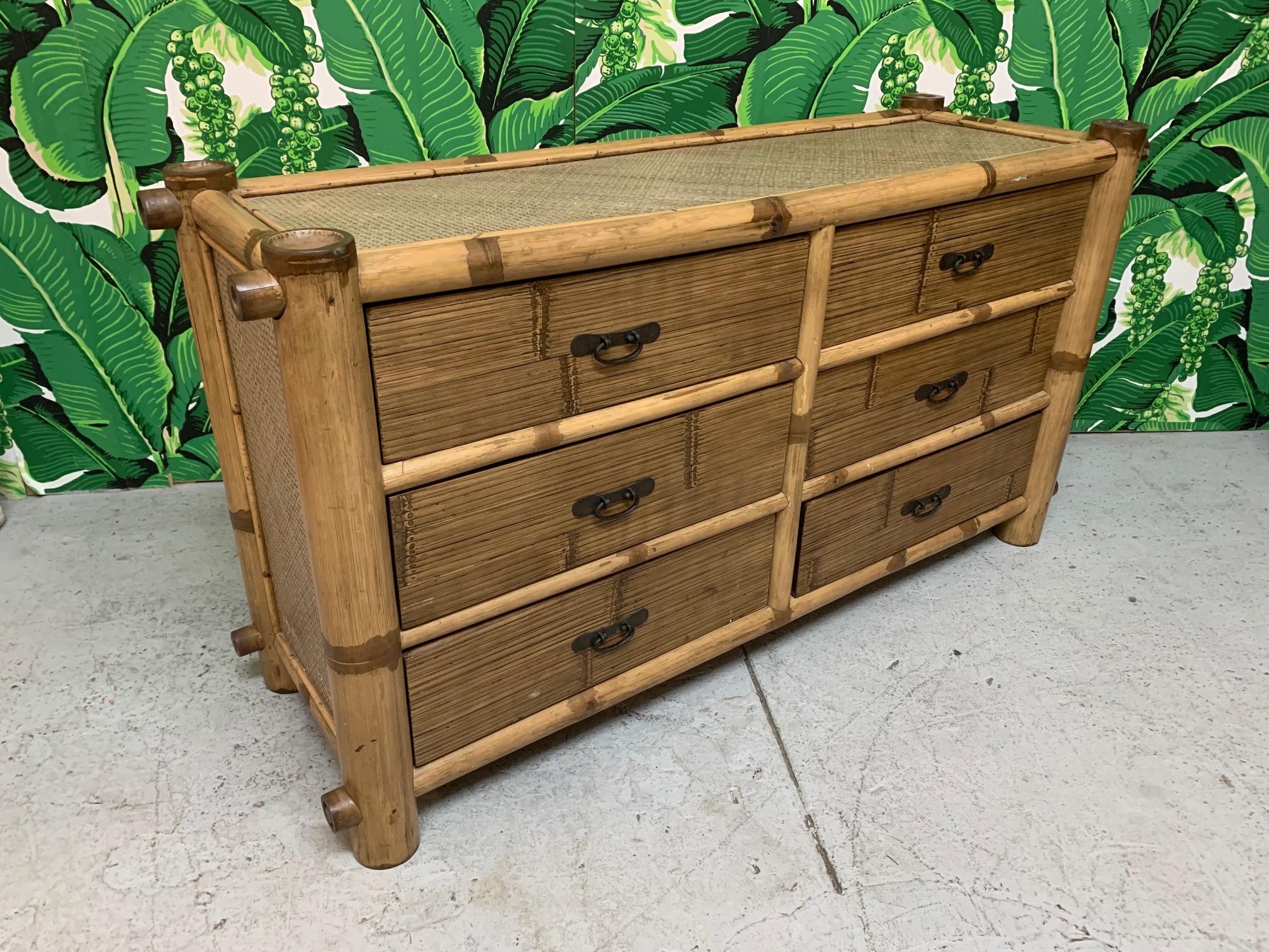 Double dresser constructed of oversized bamboo features woven rattan veneered sides and horizontal rattan veneered drawer fronts. Good vintage condition with minor imperfections consistent with age.