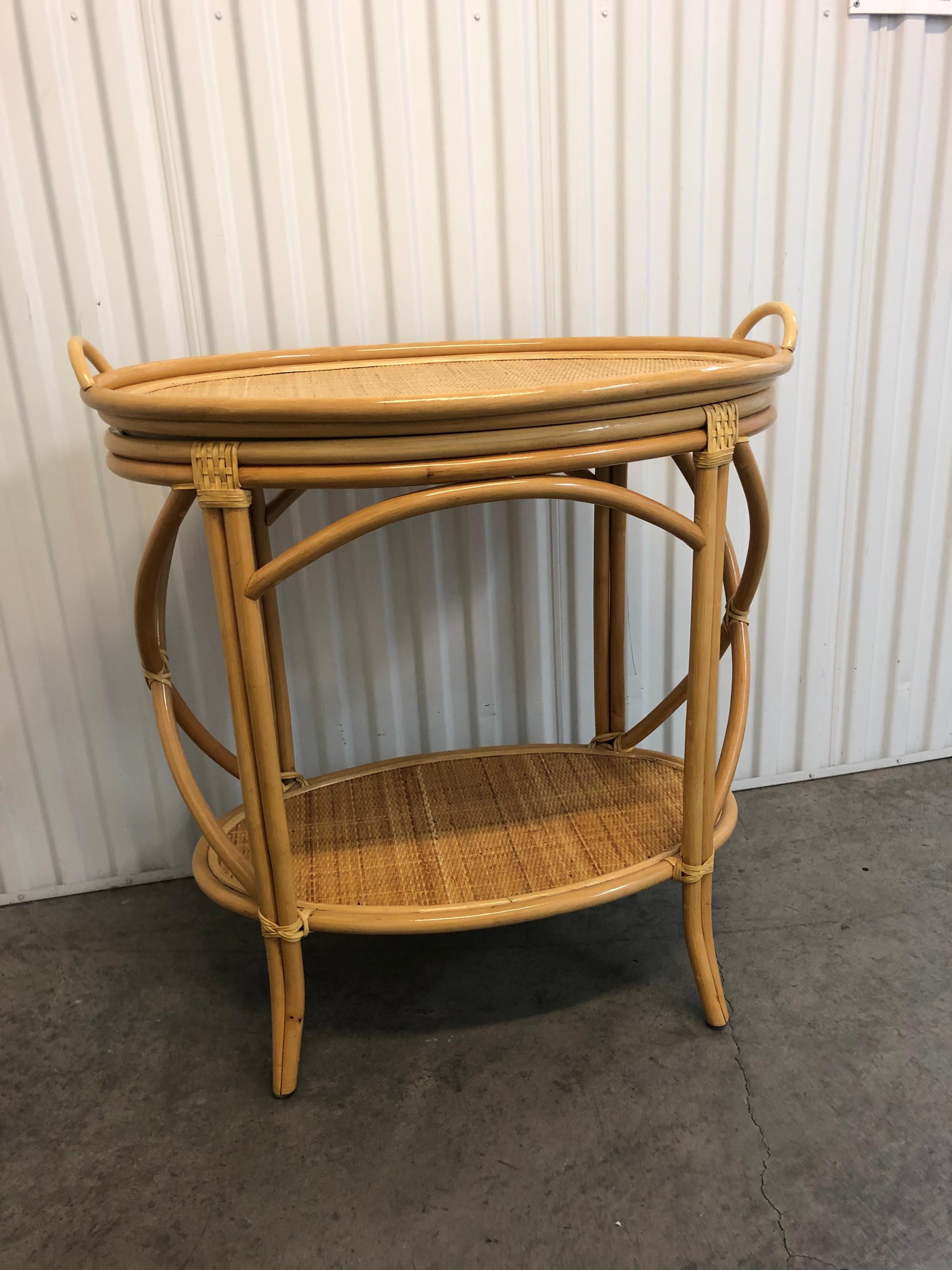 Bamboo and rattan oval bar cart.
Bent bamboo frame with removable tray and shelf.
X-side frame and rattan details. Honey color.
Size: 34