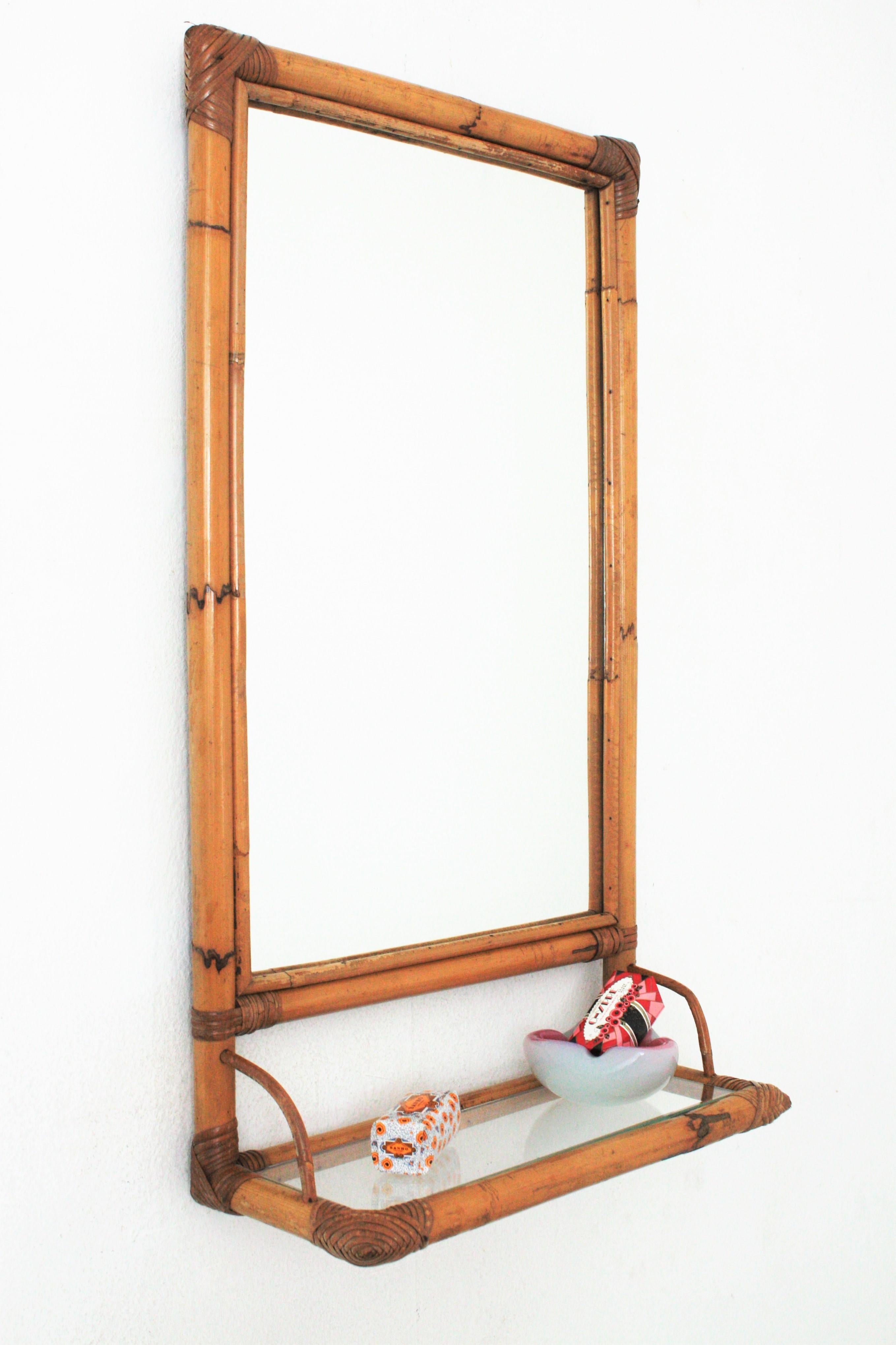 Cool handcrafted rectangular mirror with bamboo frame and glass shelf, Spain, 1960s.
This mirror features a bamboo rectangular structure holding a glass shelf. It has woven rattan accents at the corners.
This mirror will add a fresh accent to a