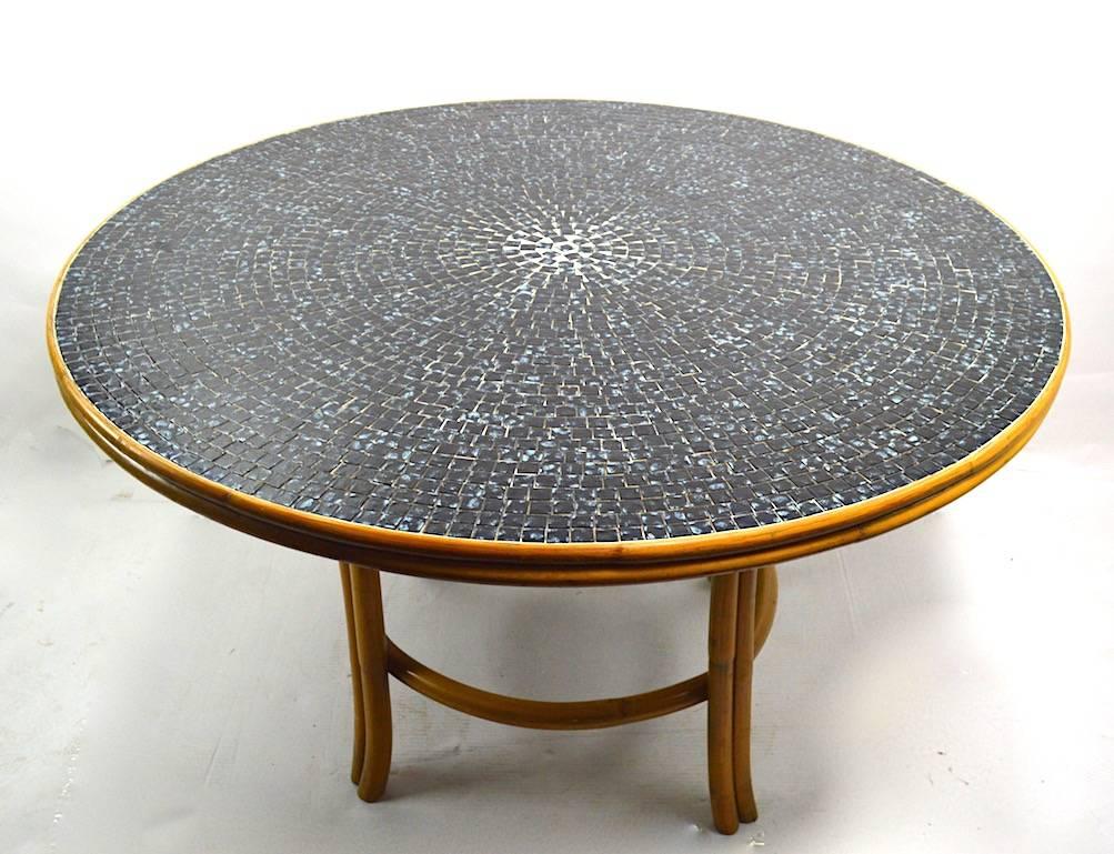 Very stylish bamboo base tile top dining or centre table, in excellent original condition. The top consists of two tone (very dark, and lighter blue) square tiles which radiate out from the centre, the base is finished bamboo. Perfect table for a