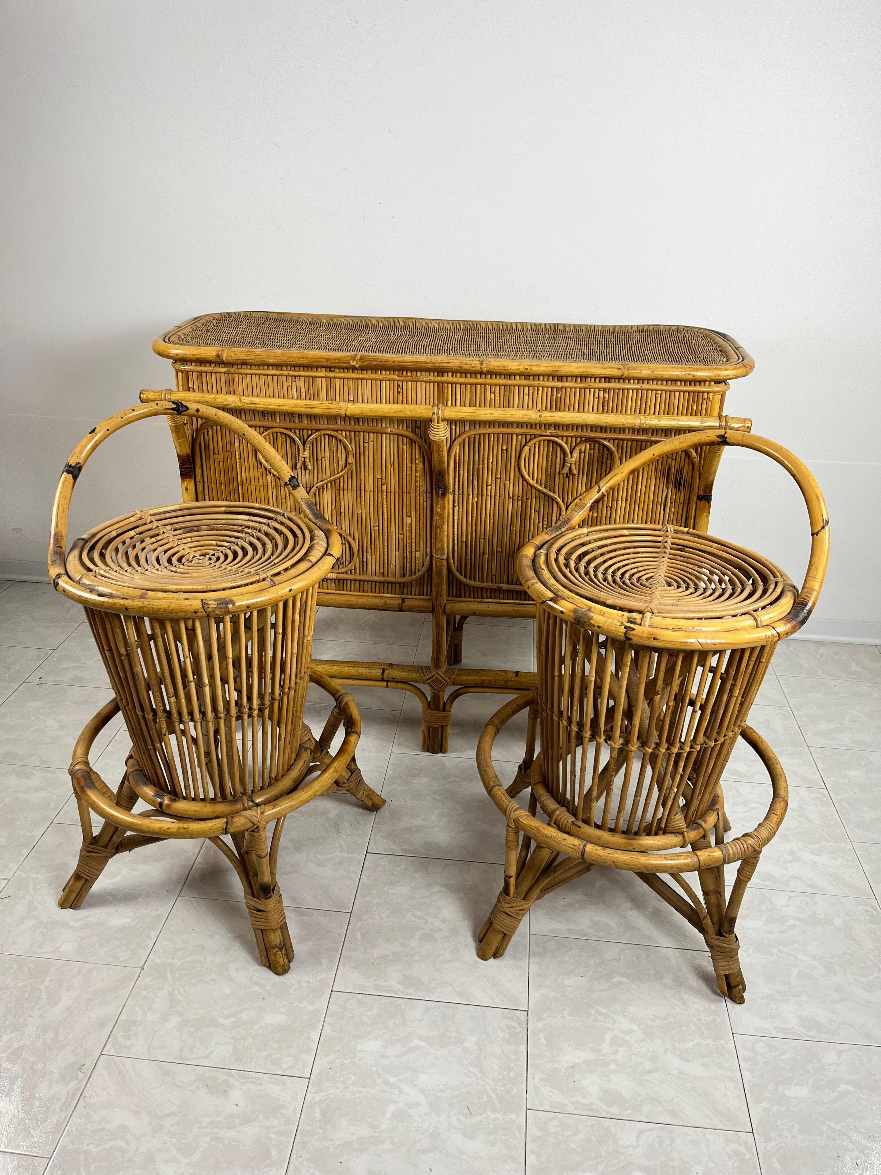 Bamboo and wicker bar cabinet with stools attributed to Tito Agnoli, 1950s, 3 pieces. The cabinet is equipped with two doors.
Excellent condition, small signs of aging.
The bar cabinet measures 126 cm wide, 53 cm deep and 94 cm high. The two stools