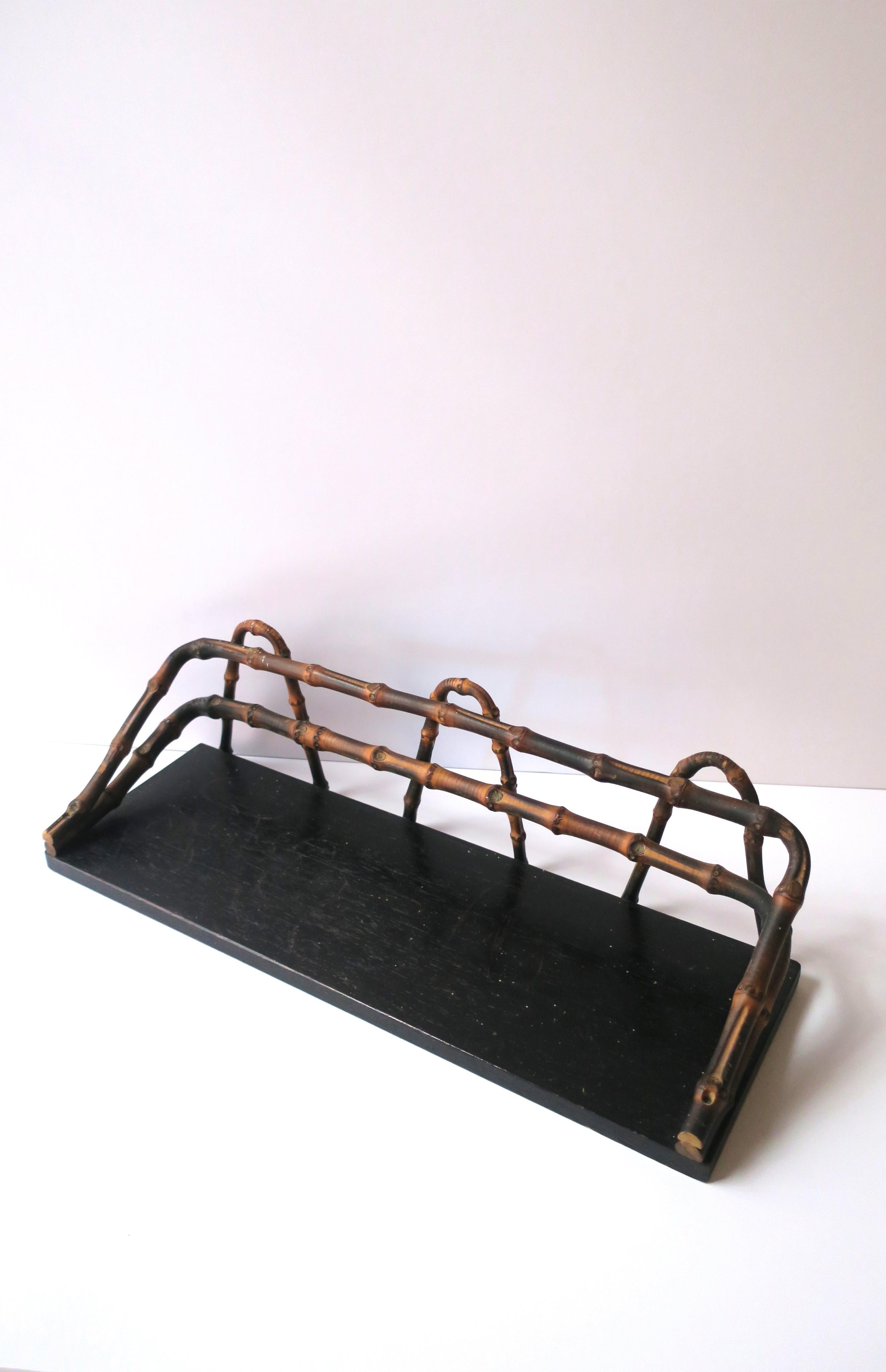 A bamboo framed wood wall shelf, circa early to mid-20th century. Wall shelf is rectangular with an ebonized wood base and a rich bamboo frame around edge. Quality bamboo as shown. A great piece to hold items in a bath or vanity area (as