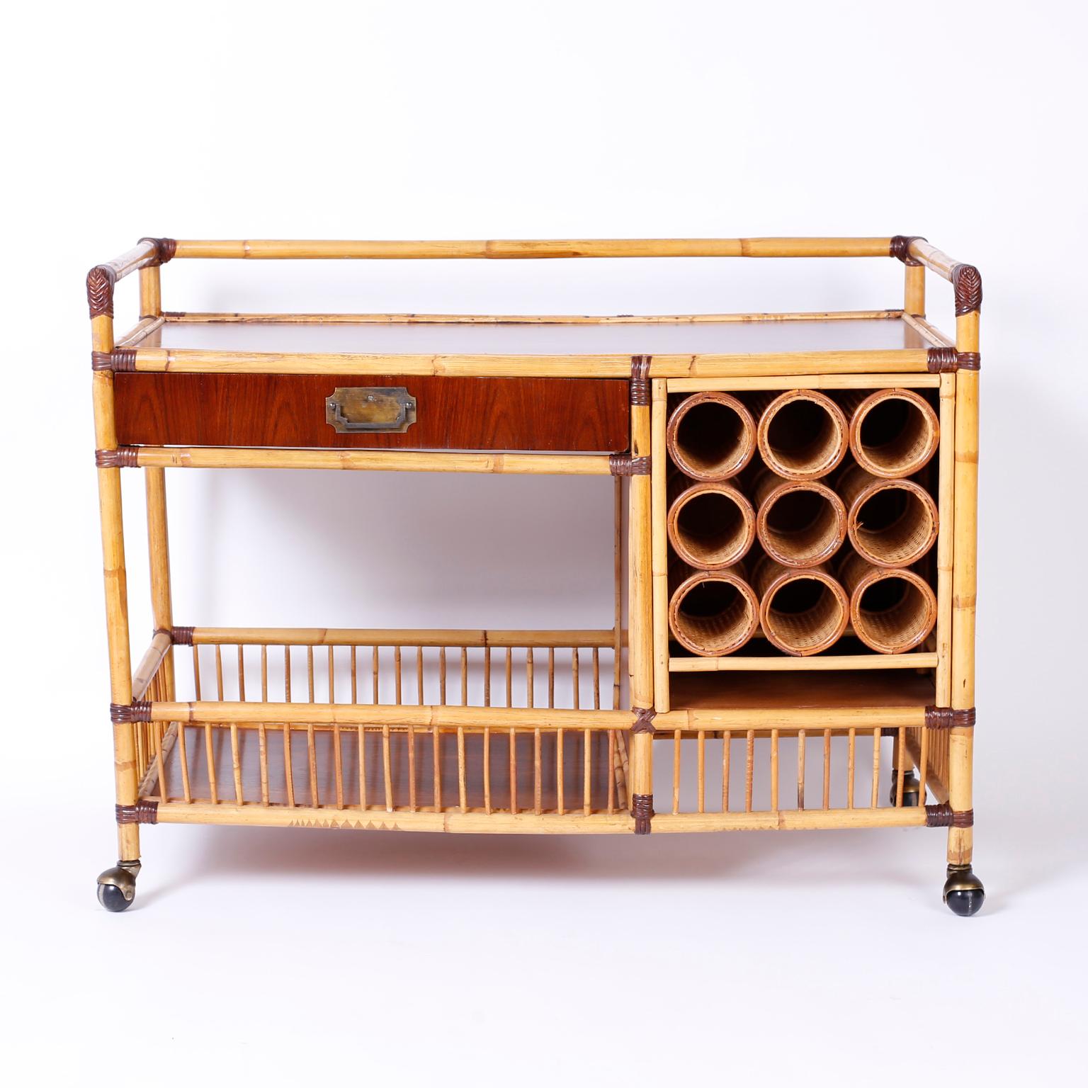 Swank midcentury bamboo and mahogany bar cart with rattan wrapped
corners, service space, one drawer, a wine rack and storage below.
Finished all the way around and gliding on wheels.