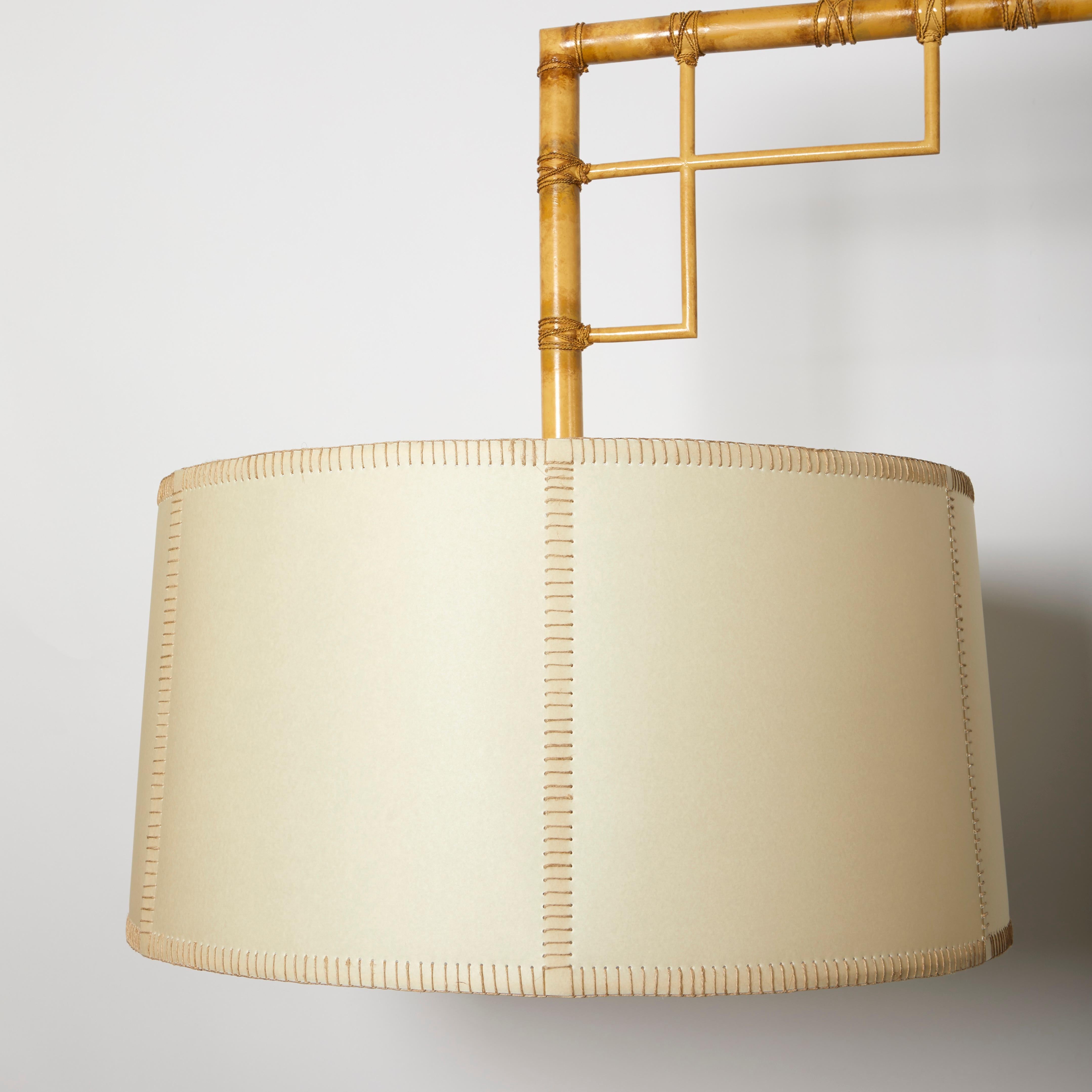Il mobile da biliardo Bamboo di David Duncan Studio è caratterizzato da una struttura geometrica intricata formata da sezioni incrociate di finto bambù dipinte a mano e realizzate in ottone, con paralumi in finto pergamena che nascondono 2 prese