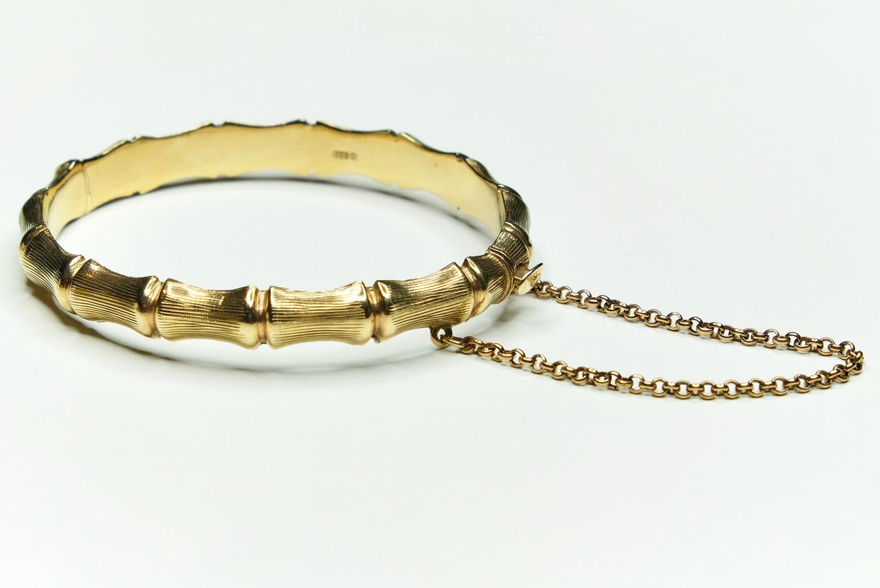 Vintage bamboo bangle in textured 9k yellow gold. Made in Birmingham In 1971. Measures 6cms across the centre. Weighs 11.2gms. Safety chain. Secure click fastener to close.