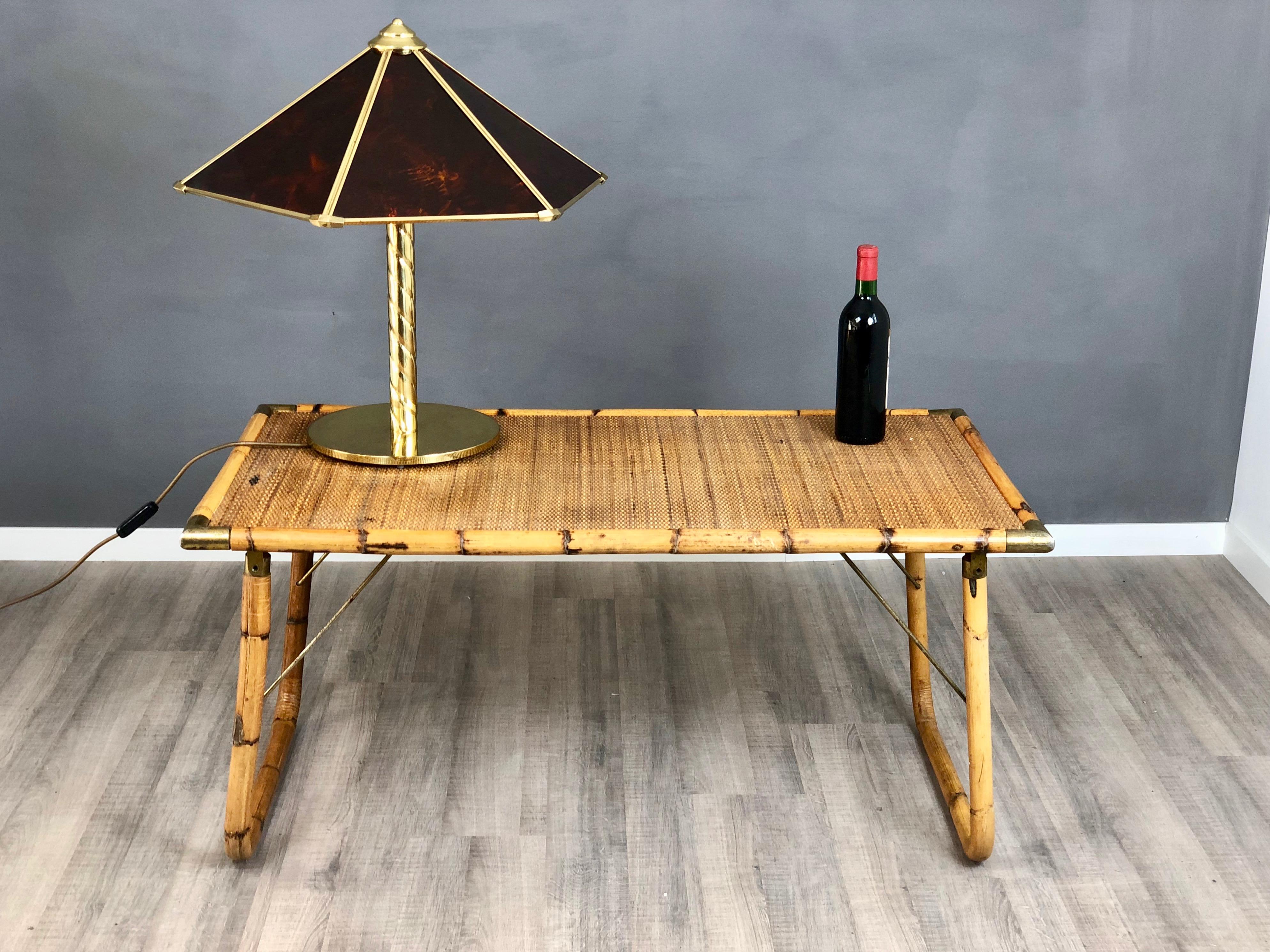 A bamboo and wicker folding side table, with bamboo frame supported by brass chains and bamboo and wicker removable top with brass corners. In the style of the Italian designer Gabriella Crespi.

The general conditions of the table are good, only