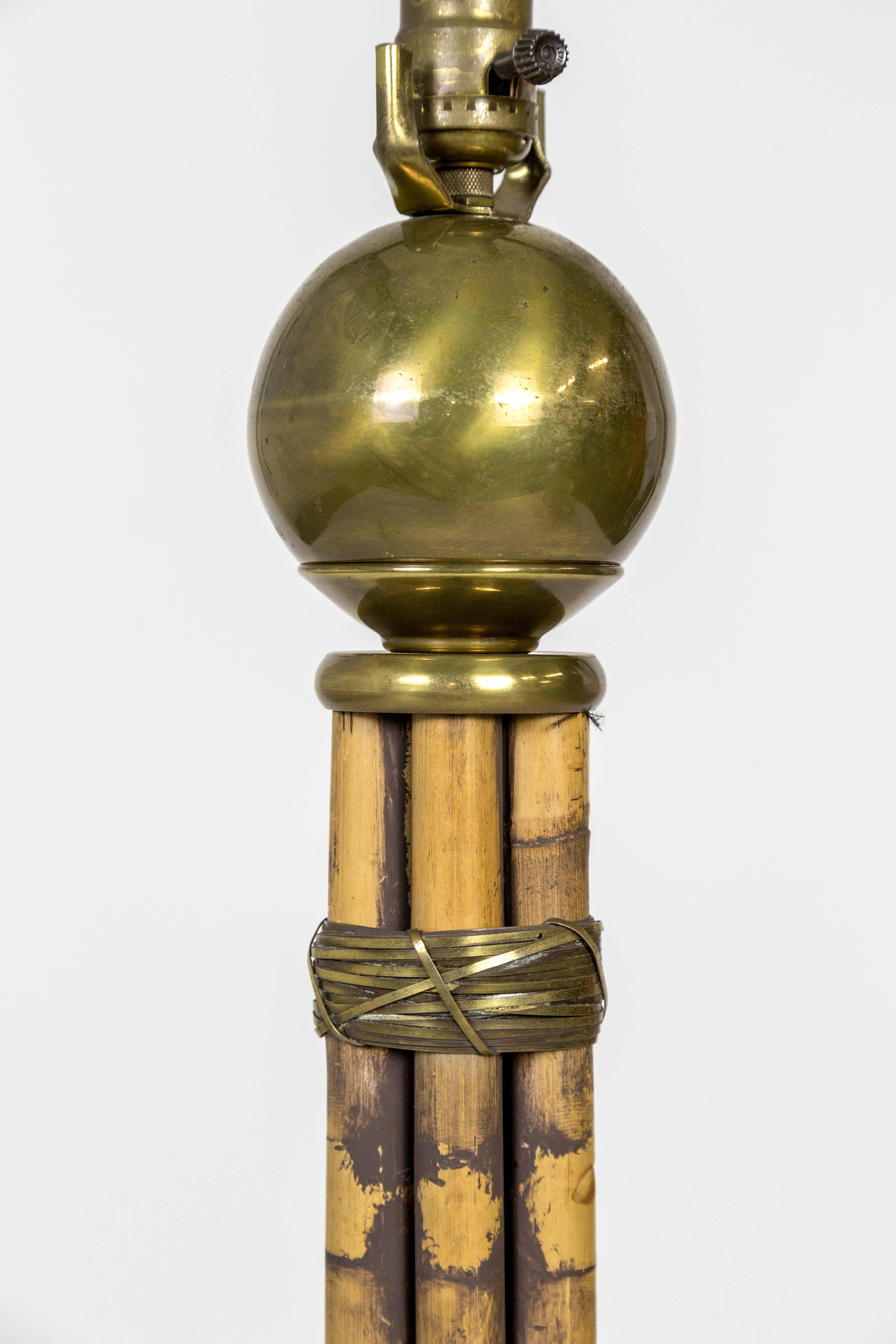 A modern, mid-20th century floor lamp of bamboo stalks artfully bound with brass wire and capped with a brass ball under the socket. Weighted brass base; rewired. Measures: 10.75