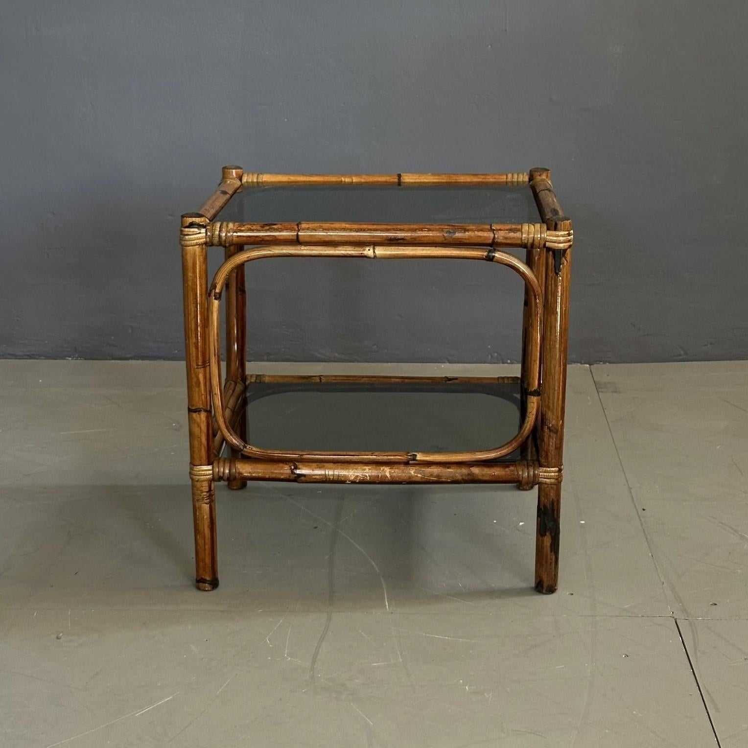 Table basse vintage en bambou, fabrication italienne des années soixante-dix.
La table basse a une structure en bambou avec deux étagères en verre fumé.