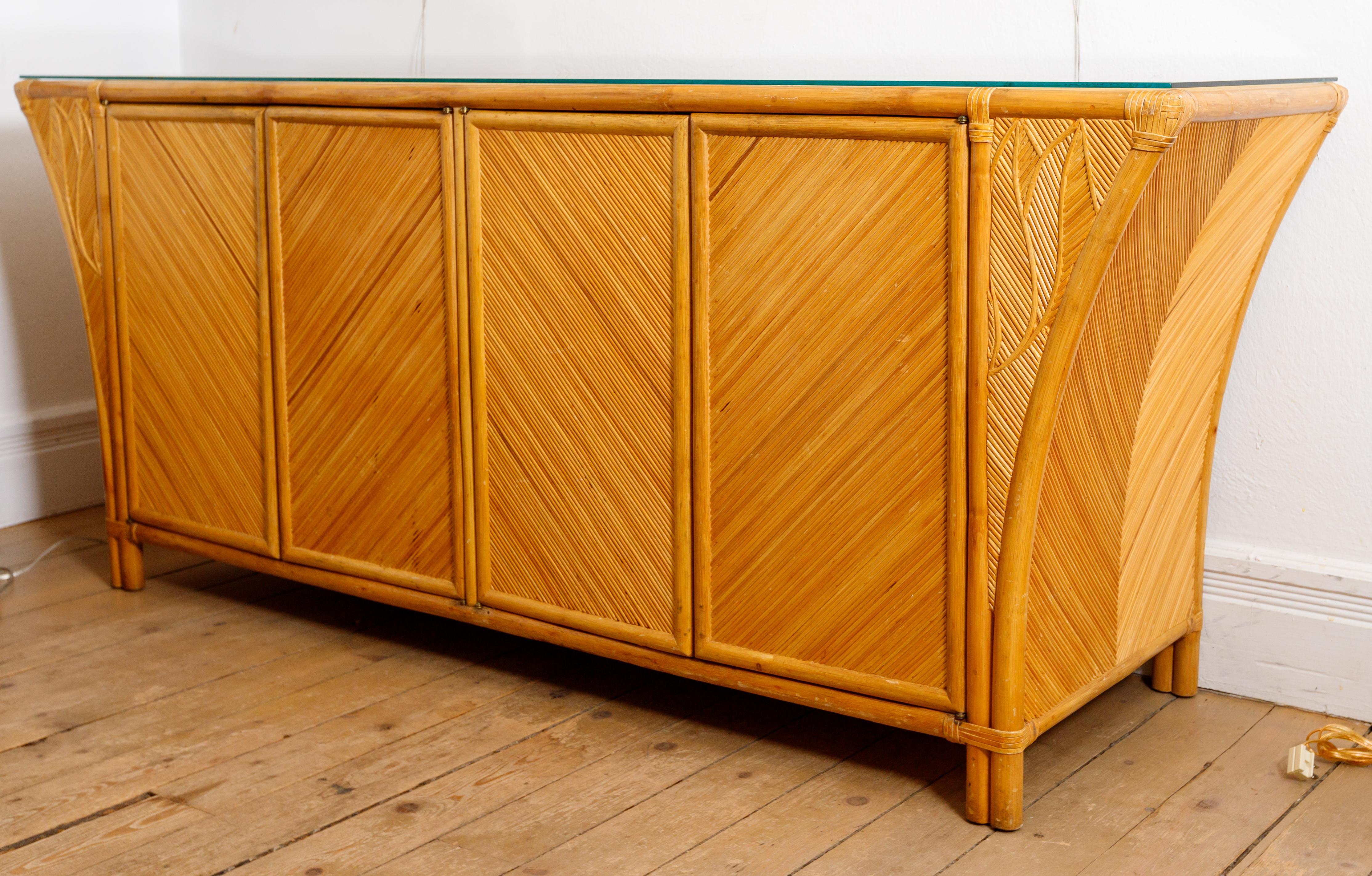Bamboo credenza featuring four doors, interior shelving and glass top.