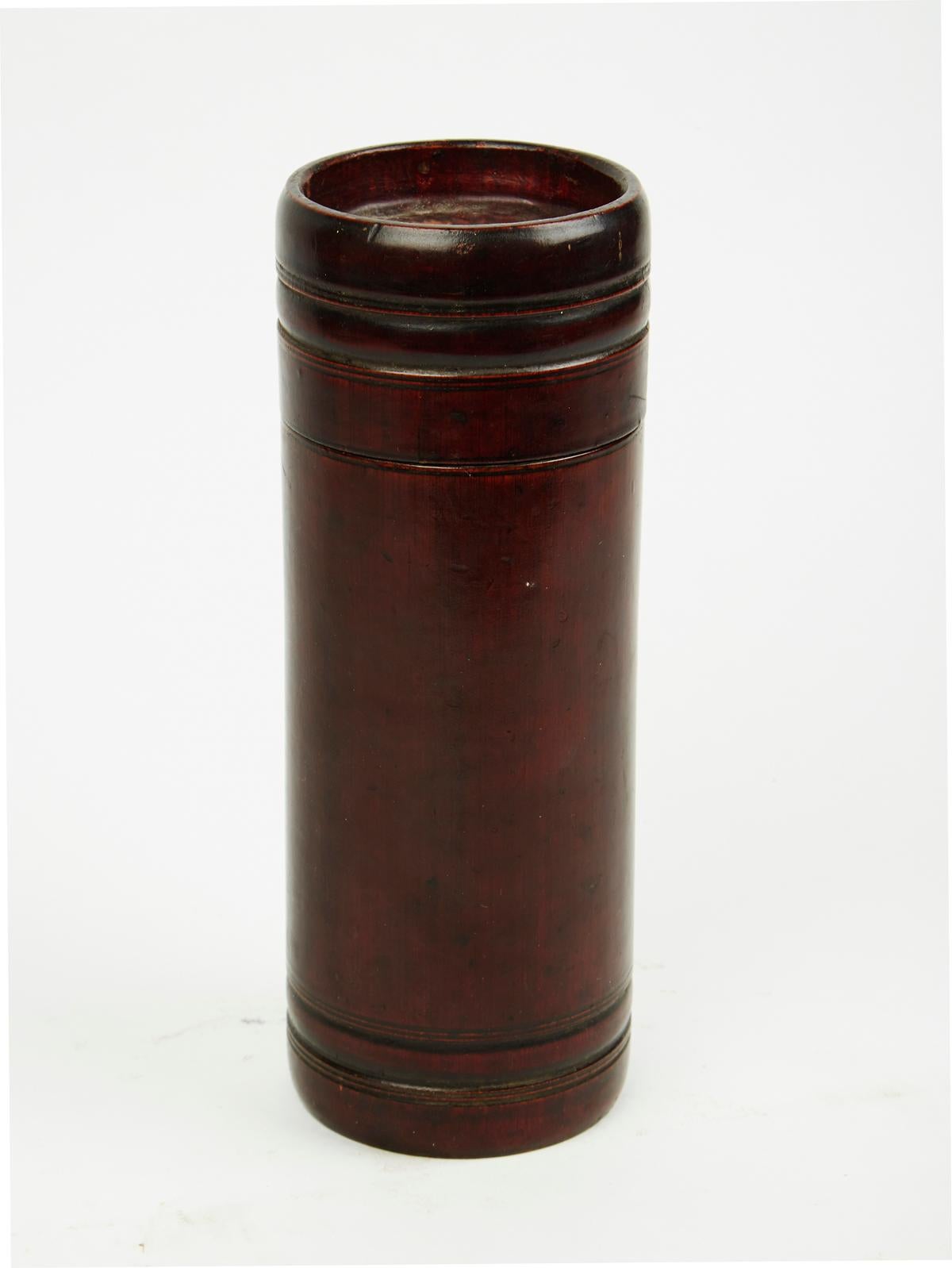 A vintage bamboo cylinder container. Hand carved and stained in dark, rich red pigment, circa 1885.