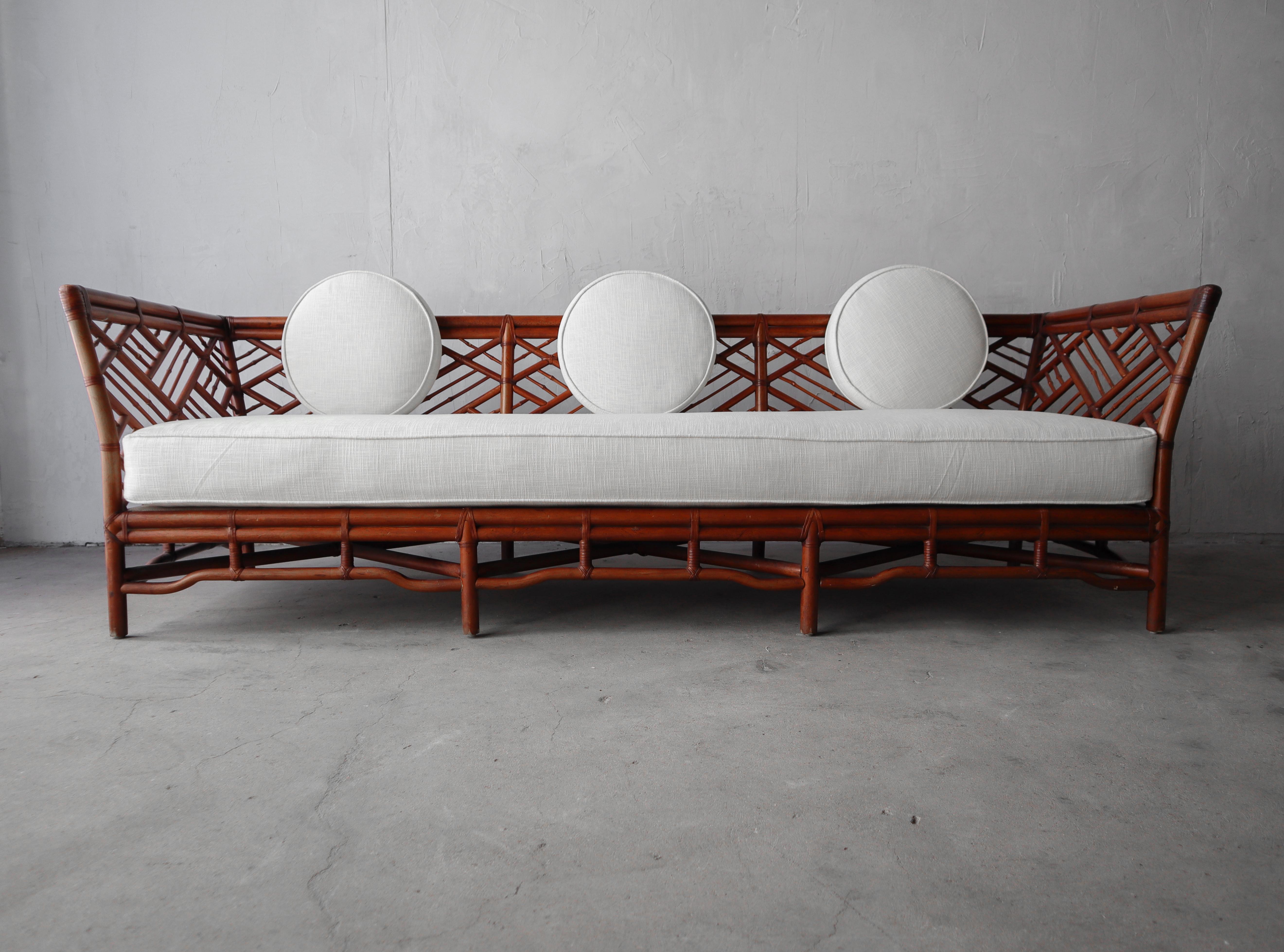 Stunning example of vintage bamboo. This gorgeous bamboo daybed sofa has show stopping details that will add warmth and texture to any space. It has been modernized with all new foam and fabric and stylish round back cushions, taking it from kitch