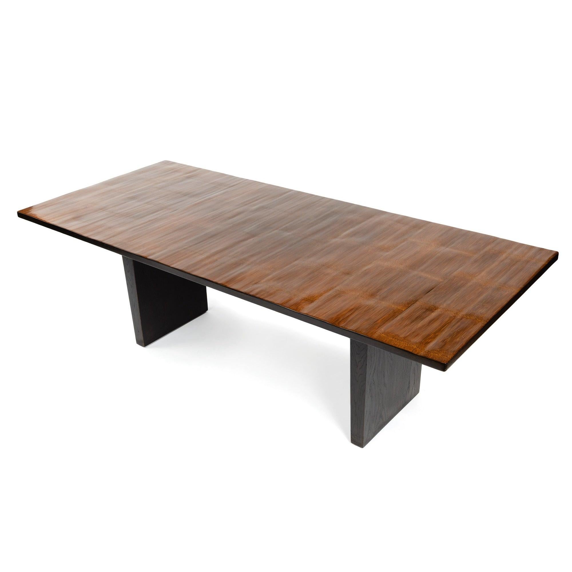 A dining table with a split bamboo top and oak slab legs in a natural oil finish.