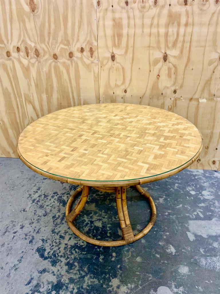 Good sized vintage circular French bamboo dining table with a practical glass top.