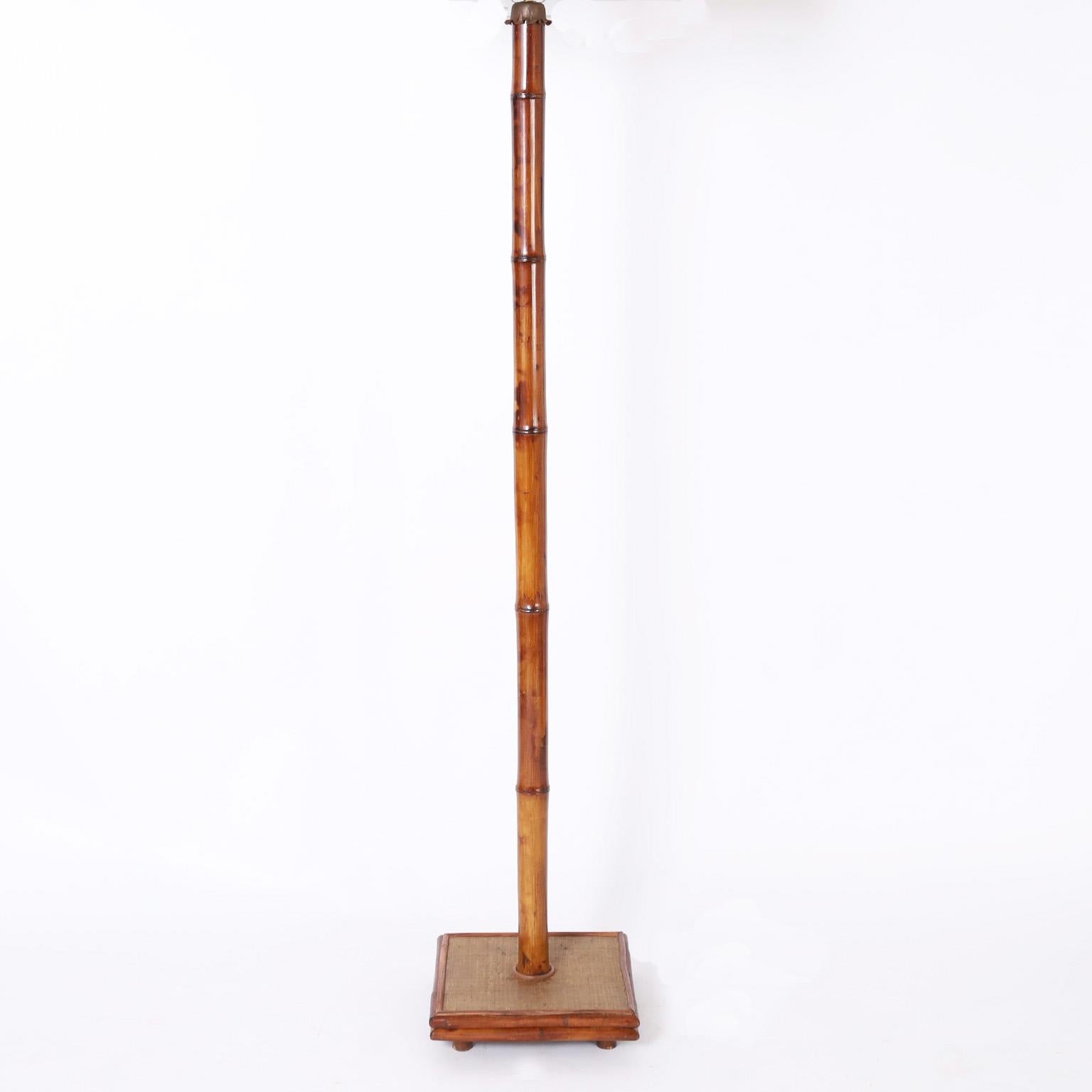 Hohe und hübsche Stehlampe aus der Mitte des Jahrhunderts mit Bambusstamm in einem Sockel aus Wachstuch, umrahmt von Bambus, erhöht mit Bambusfüßen.