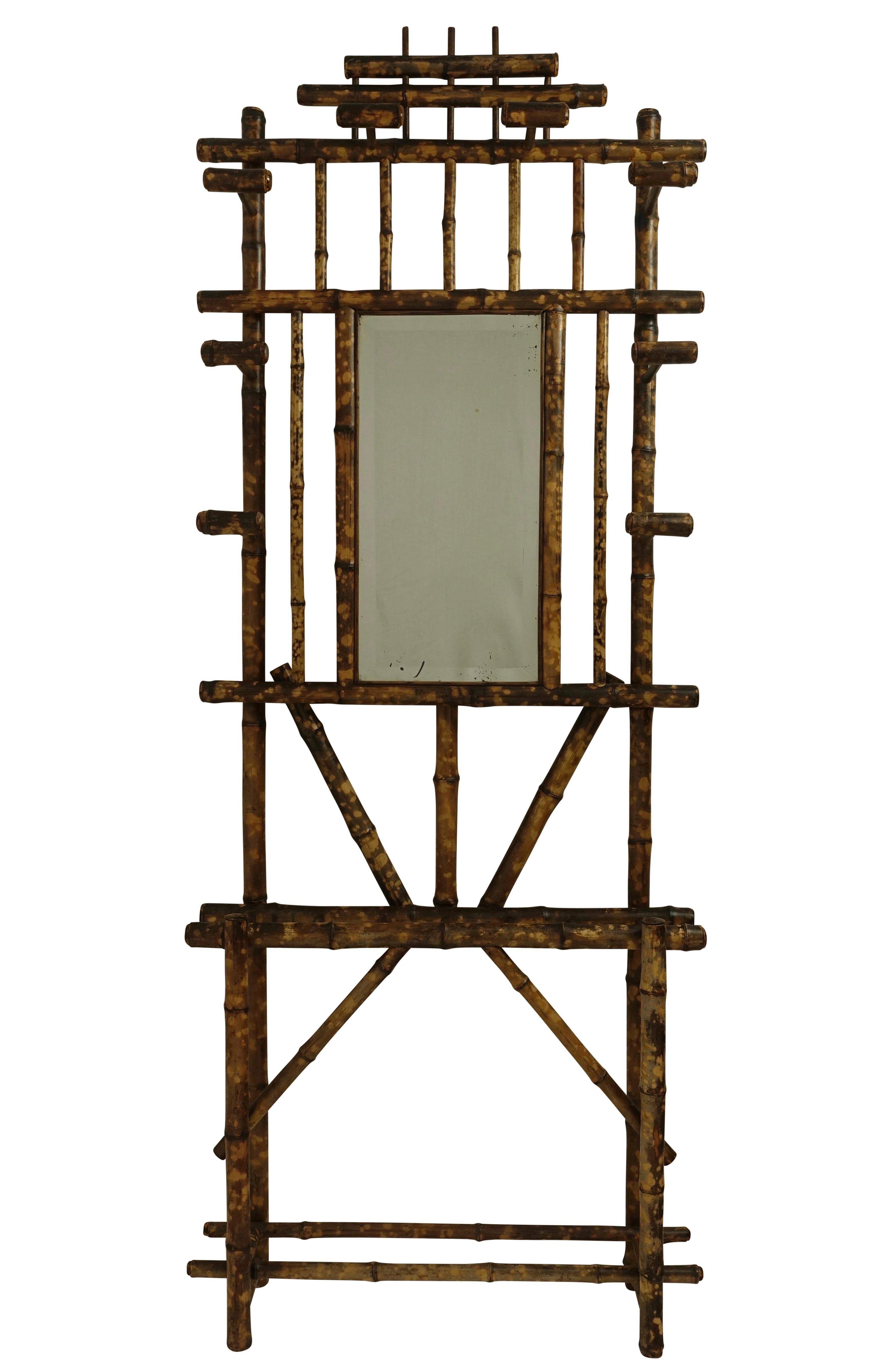 Robust bamboo hall tree, coat rack, umbrella stand with eight bamboo hooks for hanging coats and scarves framing the original large rectangular beveled mirror below which is divided spaces for umbrella, canes, hiking poles. Late 19th century,