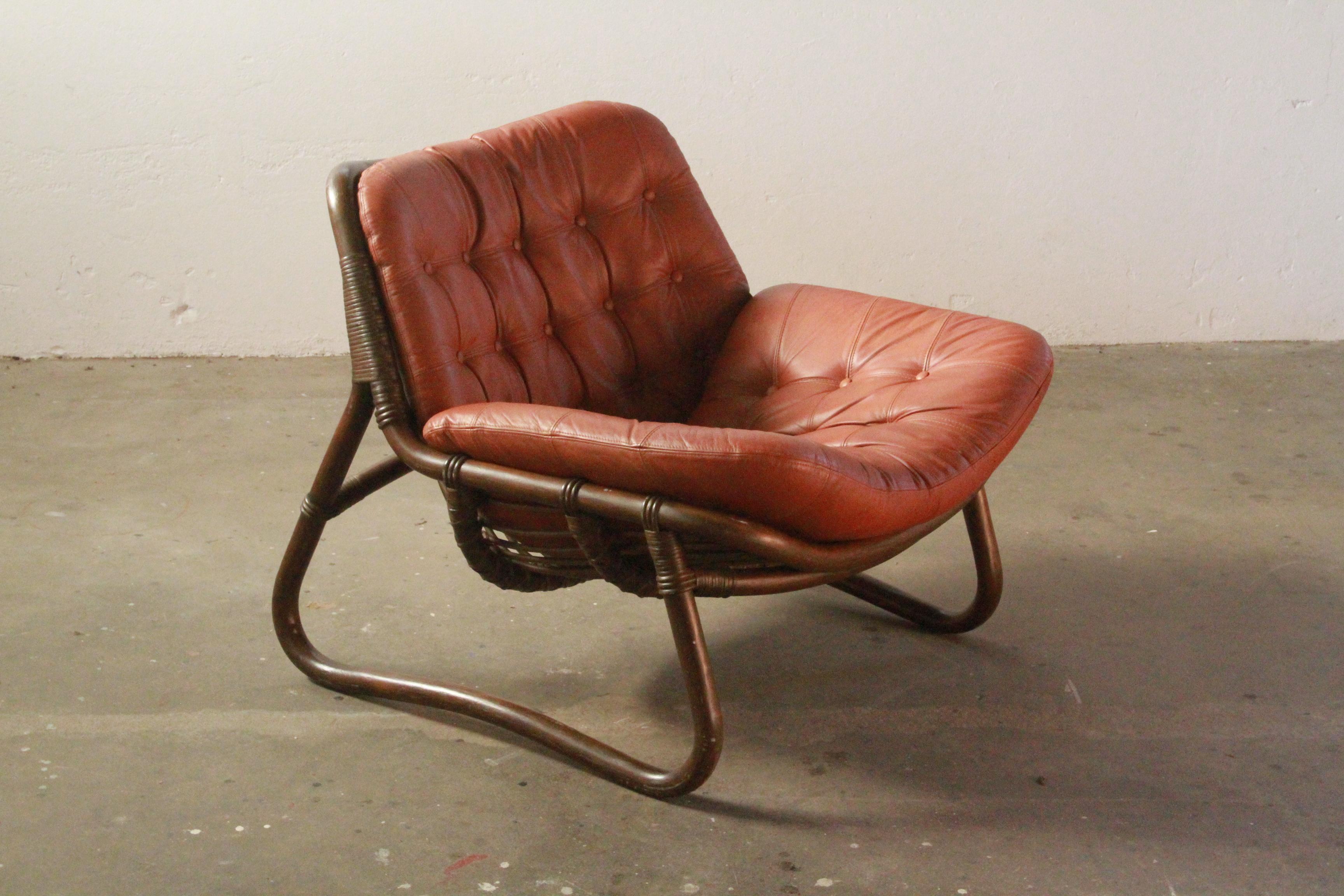 Two beautiful low leather armchairs in stunning patinated condition. The frames are completely firm and stable, and very sturdy in construction, even though they are made of bamboo. Once seated, the chairs are hard to get out of as you are