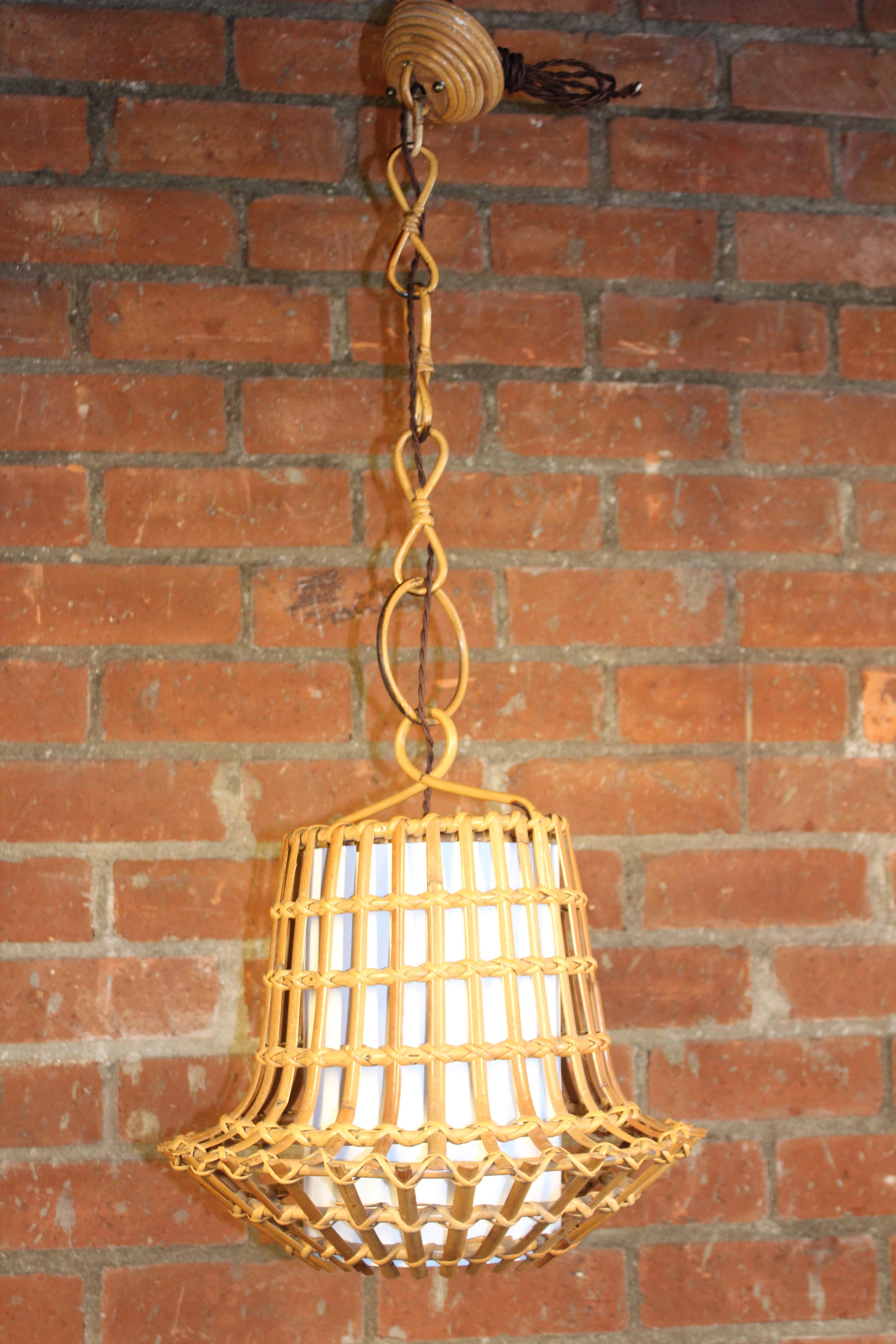 A vintage bamboo and rattan hanging pendant light fixture from Italy, 1960s. Newly rewired and fitted with a new white linen insert. Original bamboo chain and canopy. In overall wonderful condition and ready to be installed in your home. 18