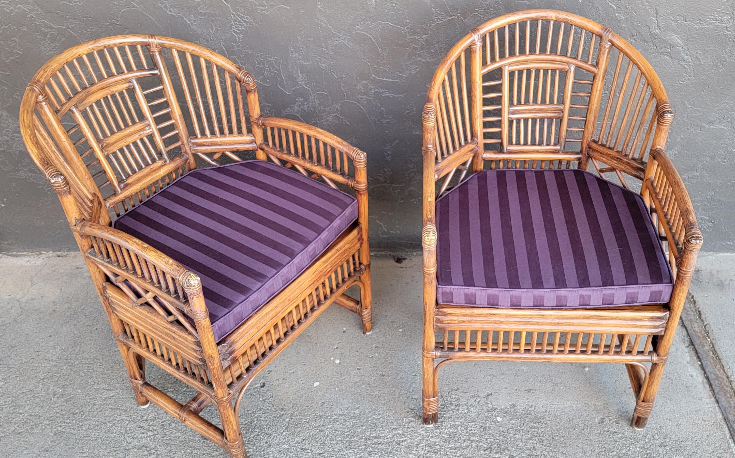 A pair of bamboo armchairs with cane seats. Very good original condition with scuffing to top surface of arms. Each chair has a reversible cushion. Late 20th century.